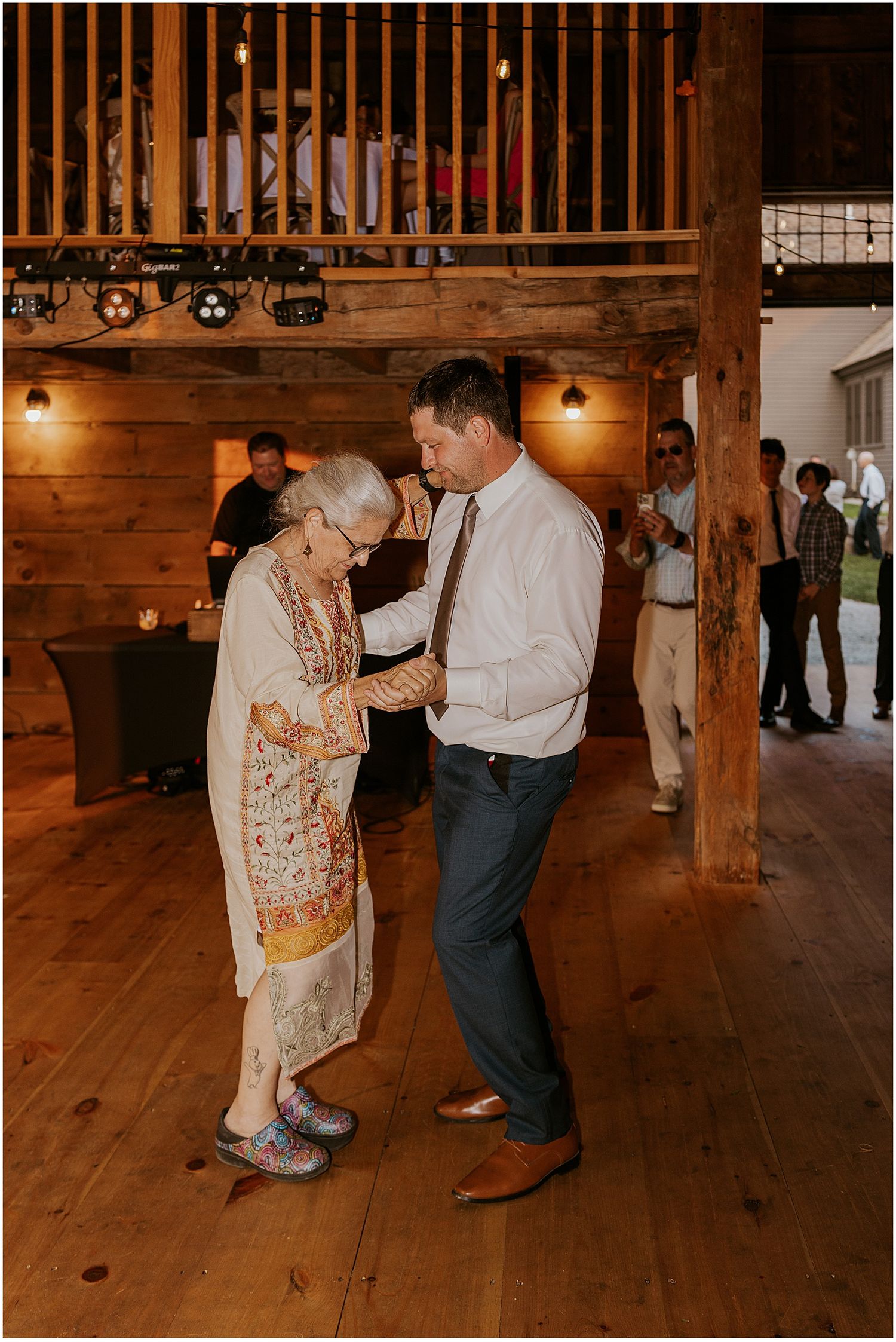 Couple dancing together on rustic wooden barn floor during special celebration.