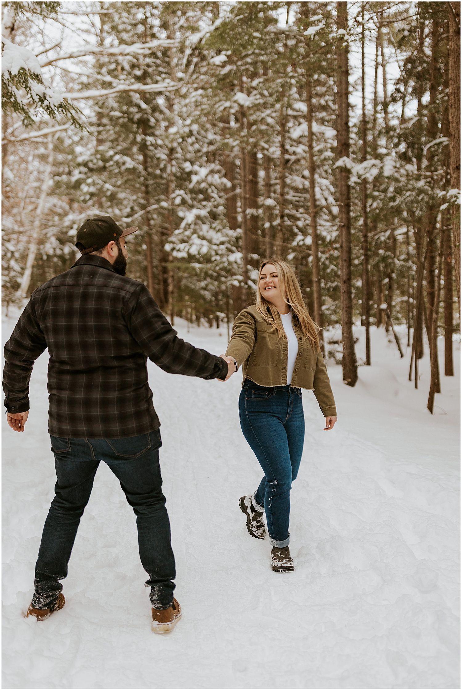 Couple taking enagement photos in New Hampshire's White Mountains wearing winter engagement photo outfits