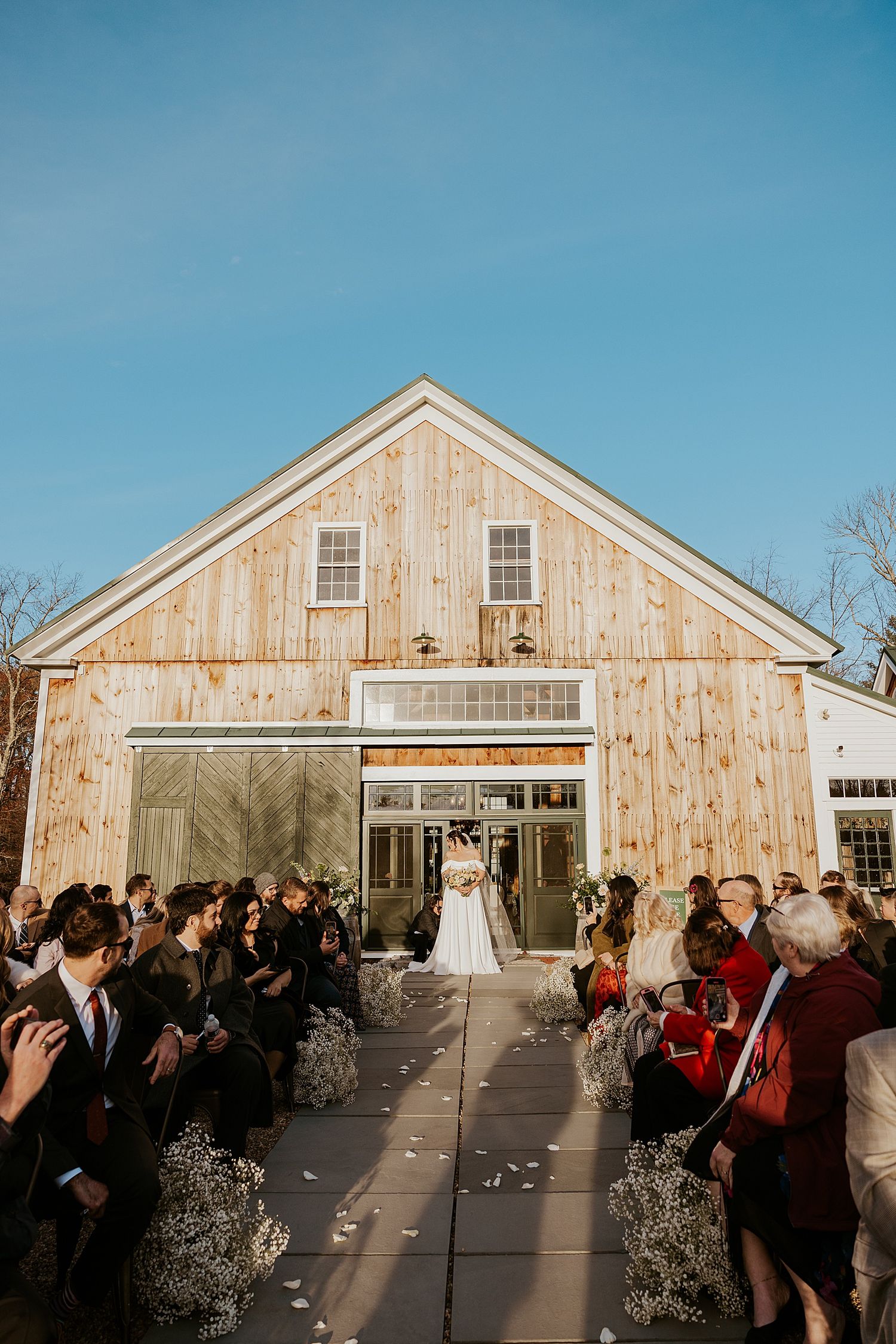 Bride walking down the aisle outdoors at her Barn at Powder Major's Farm wedding in New Hampshire