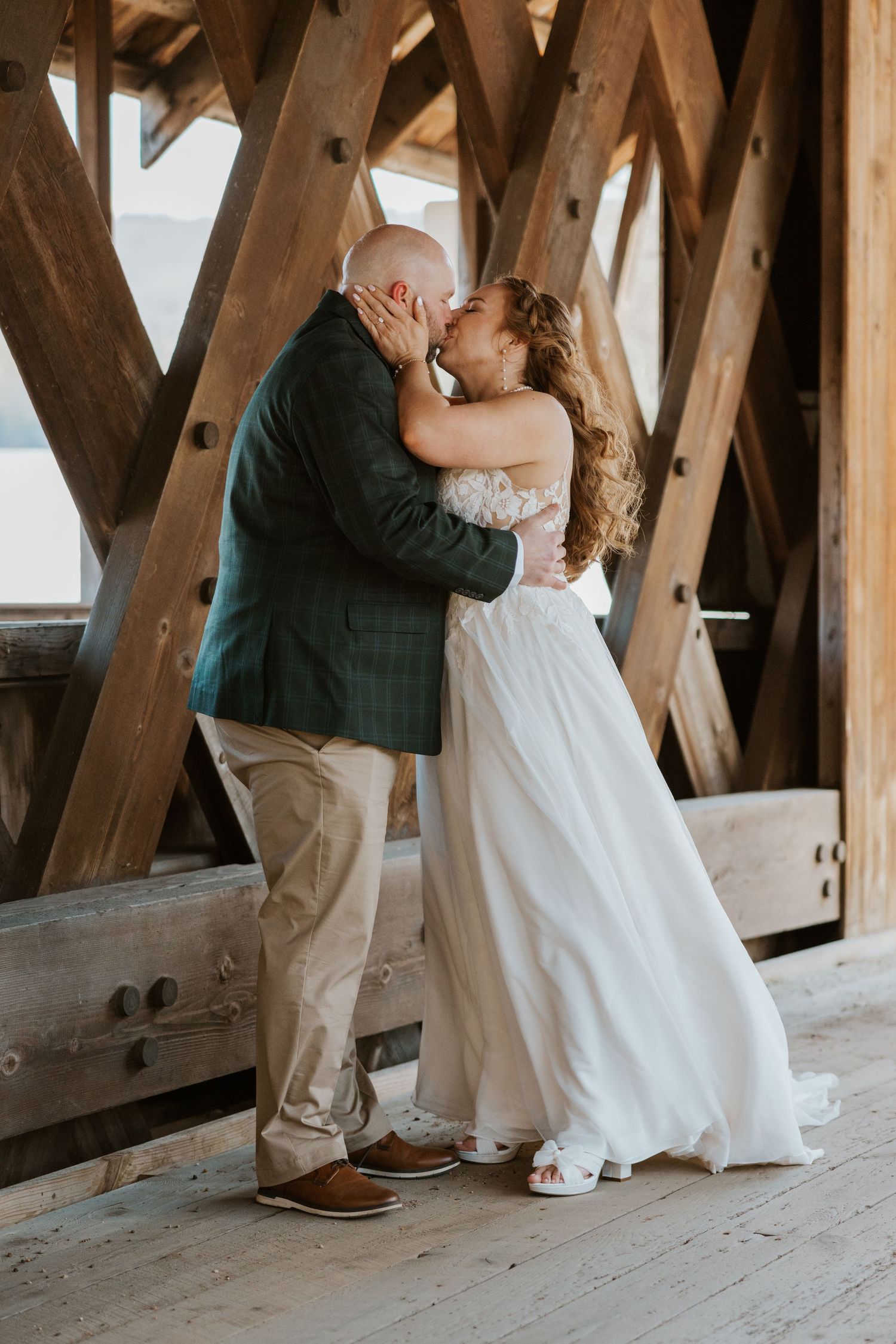 A romantic moment between newlyweds dancing in a rustic wooden barn setting.