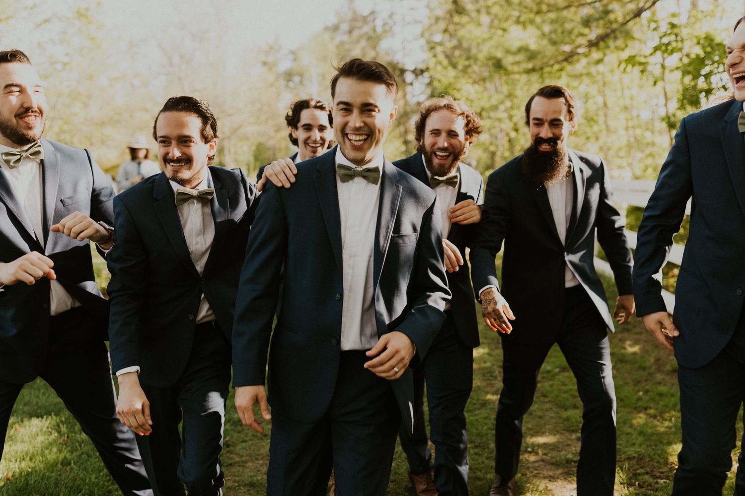 Groomsmen group photo with everyone walking and laughing and having fun together.