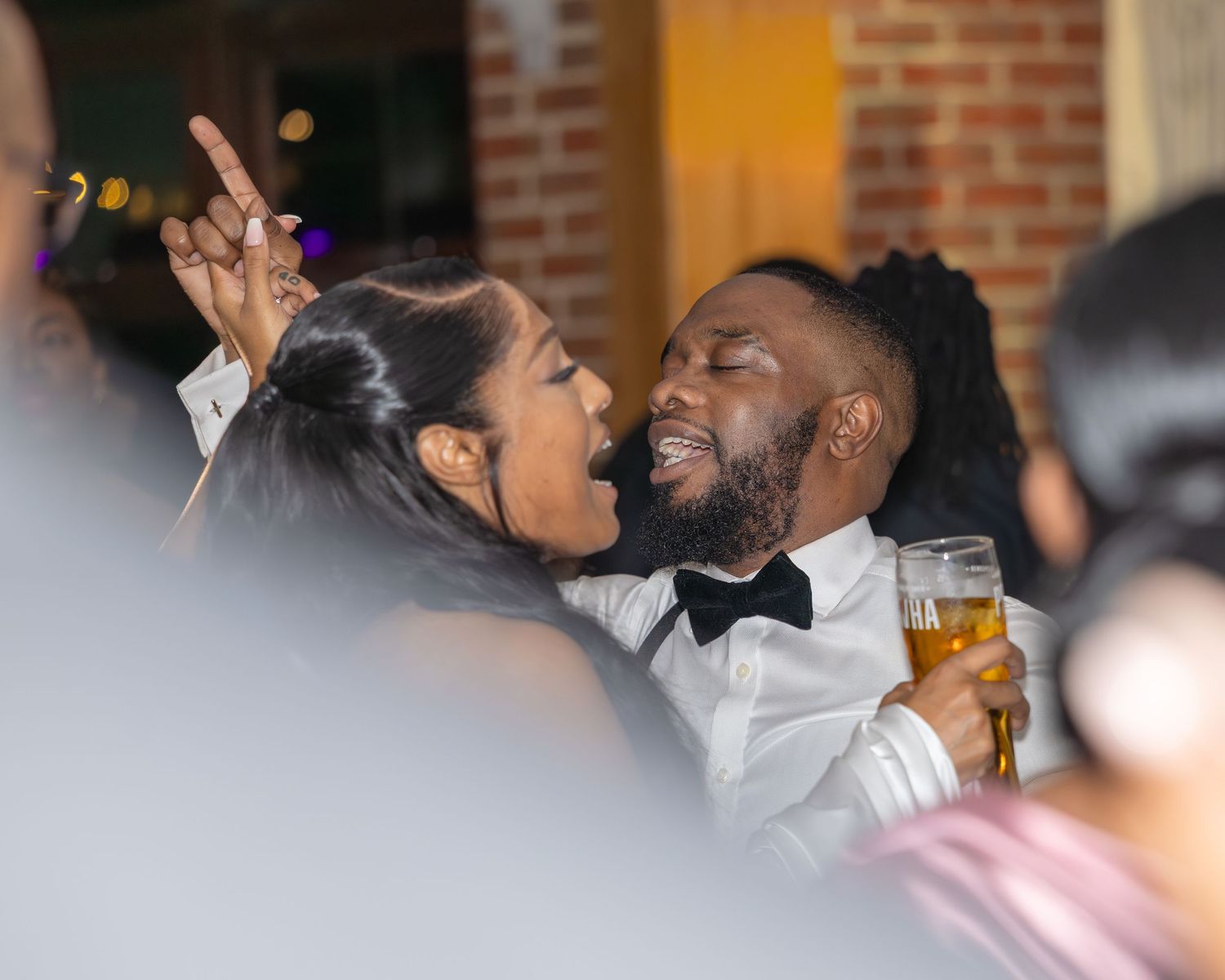 A lively couple dances and celebrates joyfully at a wedding reception party.