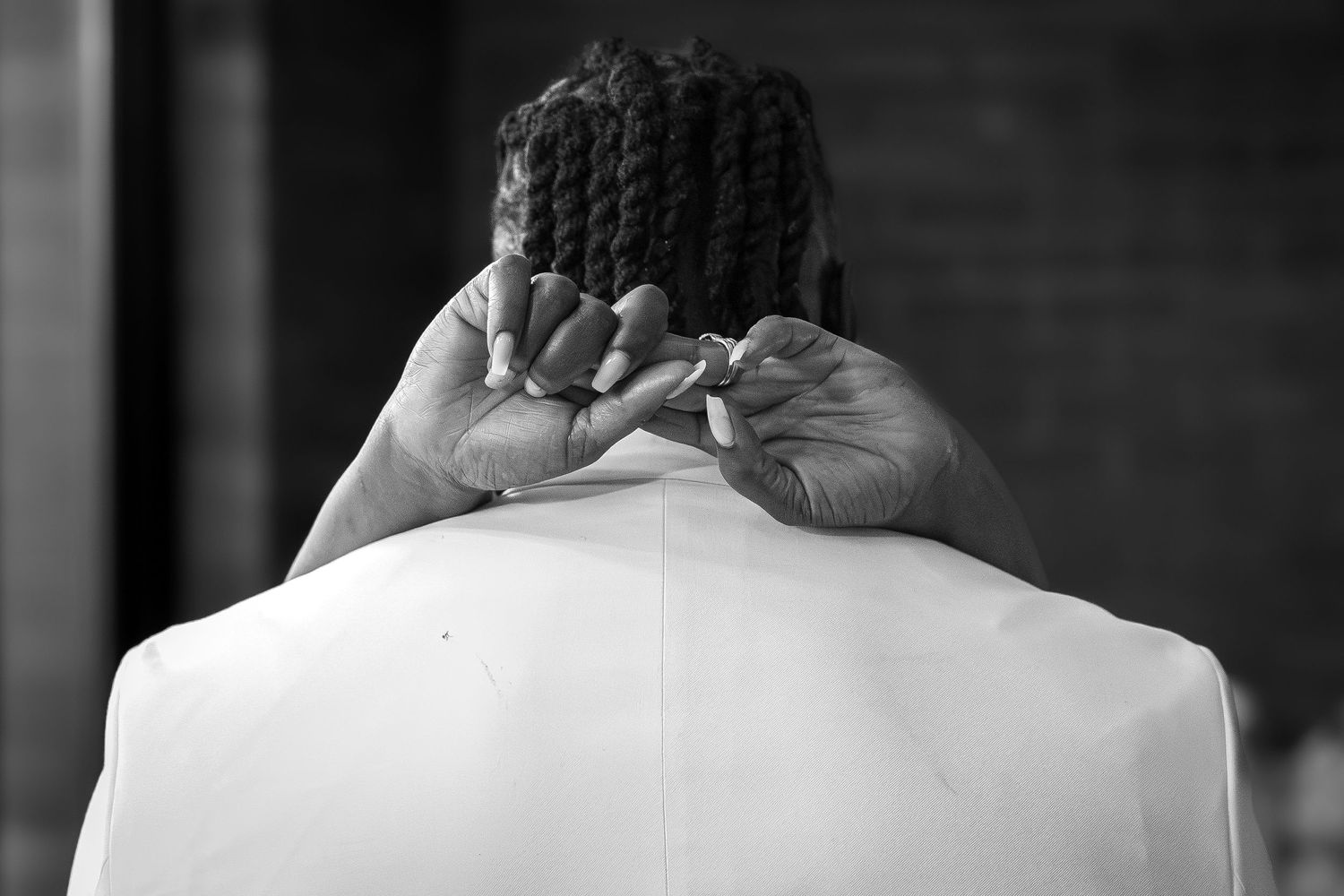 A black and white close-up photograph of a bride's braided hairstyle.