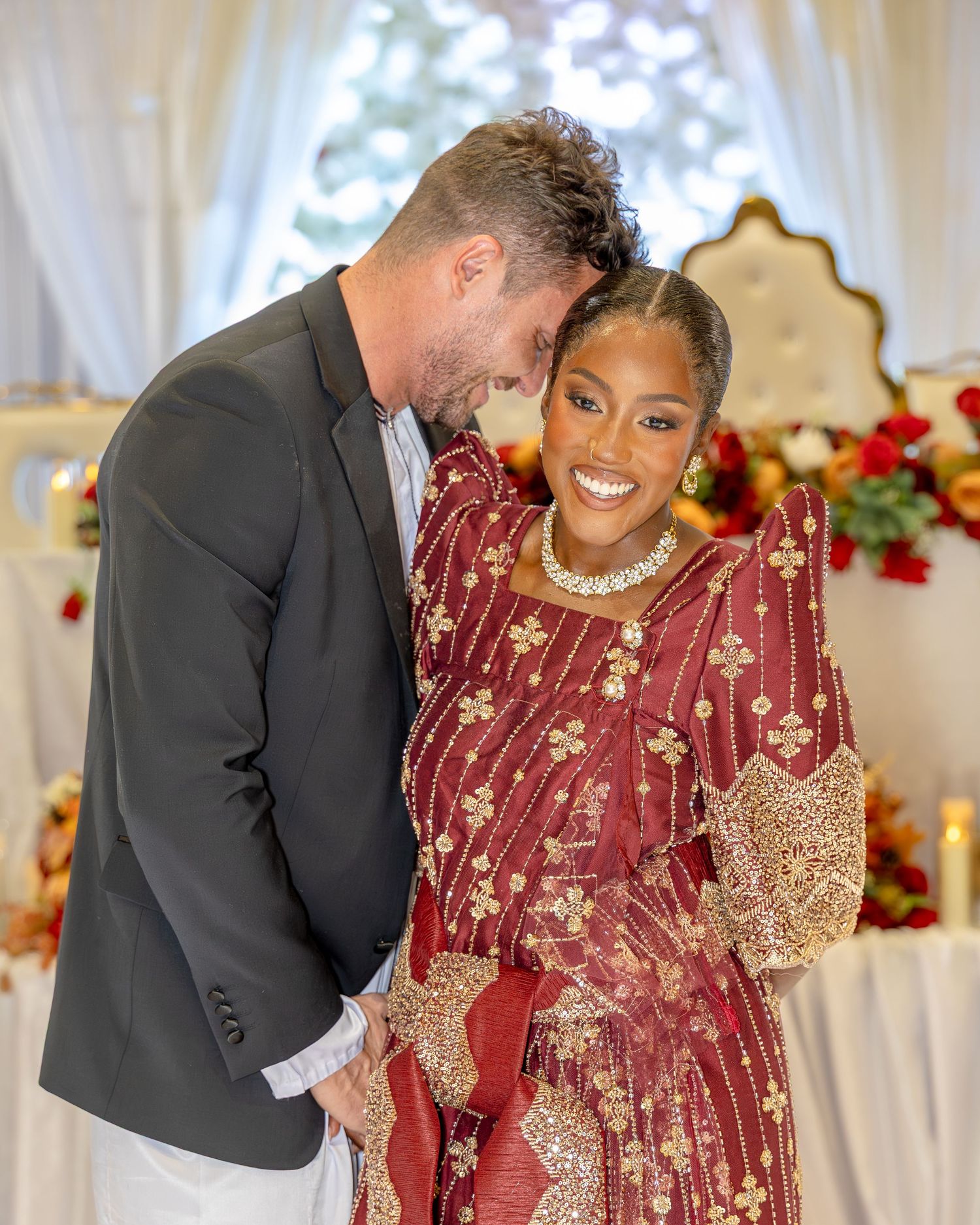 Candid moments of celebration at an indoor event with white curtains and floral decor.