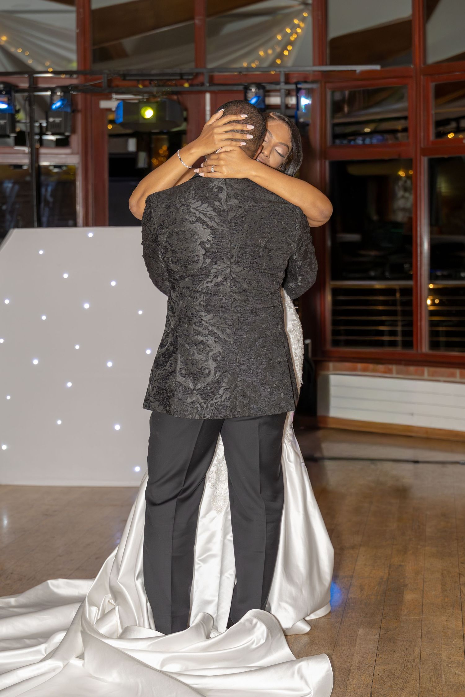 Bride and groom share an intimate embrace during their first dance at their wedding reception.