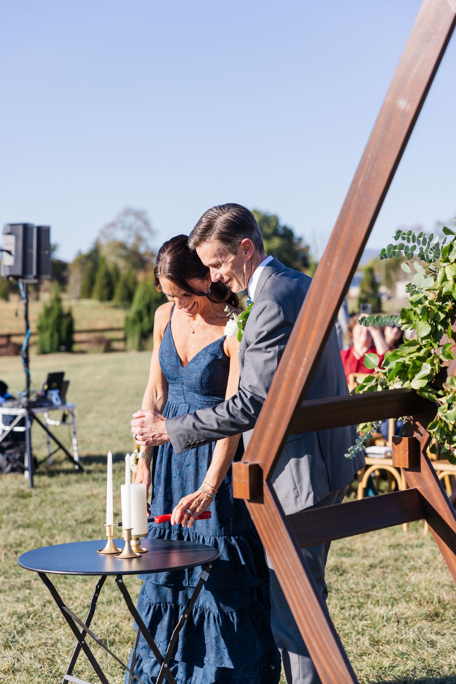 A couple shares an intimate moment during their first dance at an outdoor wedding reception.