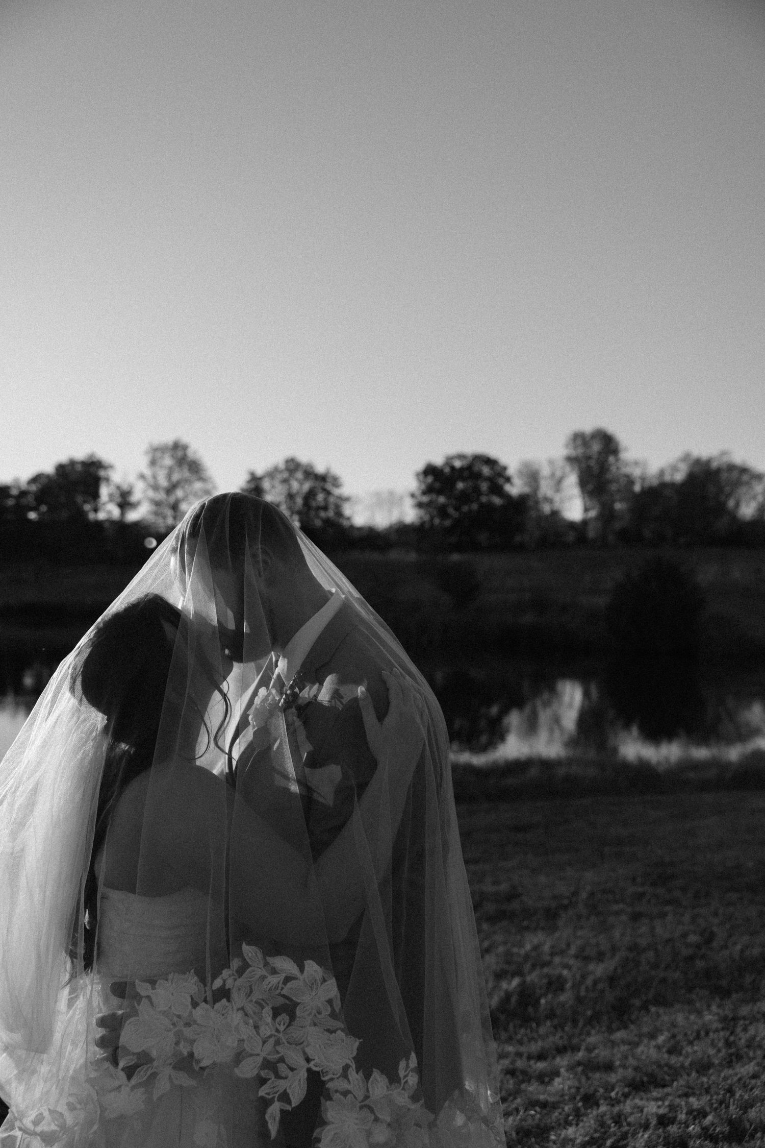 Silhouetted wedding dress details against sunset sky.