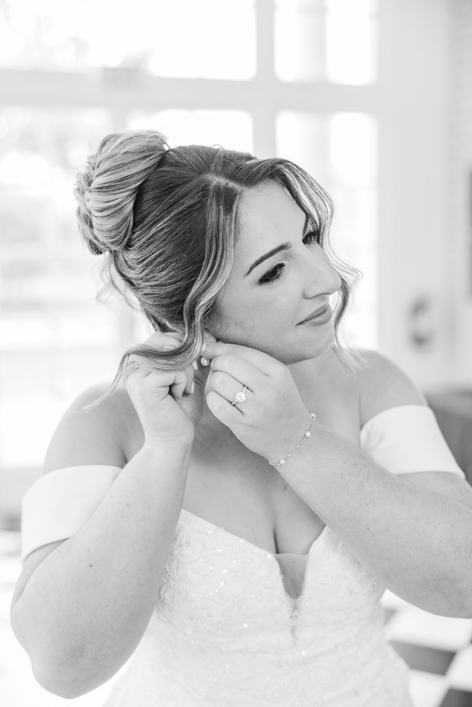 Black and white close-up shots of a bride adjusting her earrings and hair.