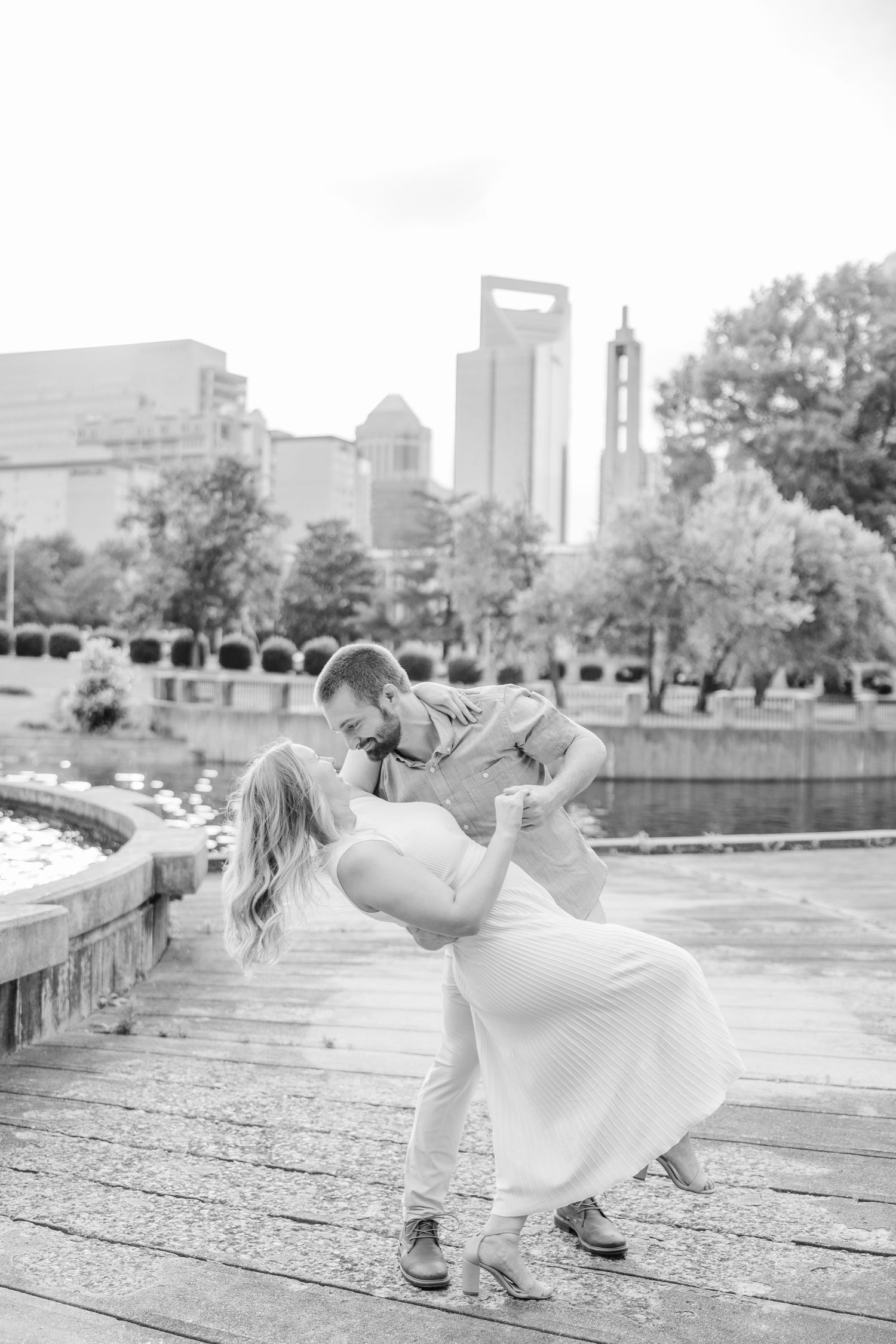 A romantic dance pose with the Charlotte skyline visible in the background on a wooden deck.