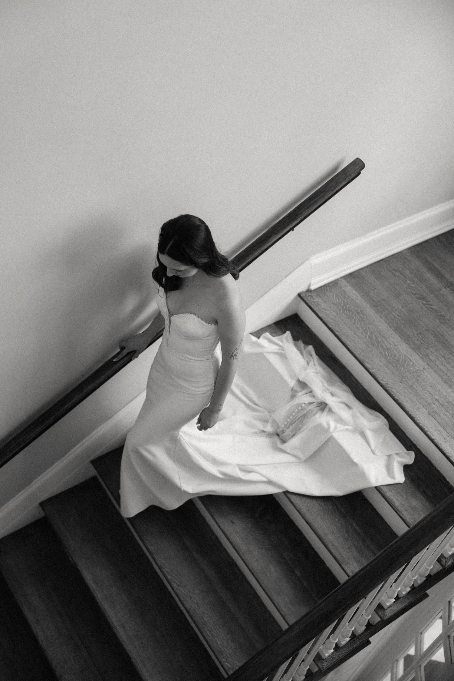 Black and white sequence showing someone descending stairs in a flowing white dress.