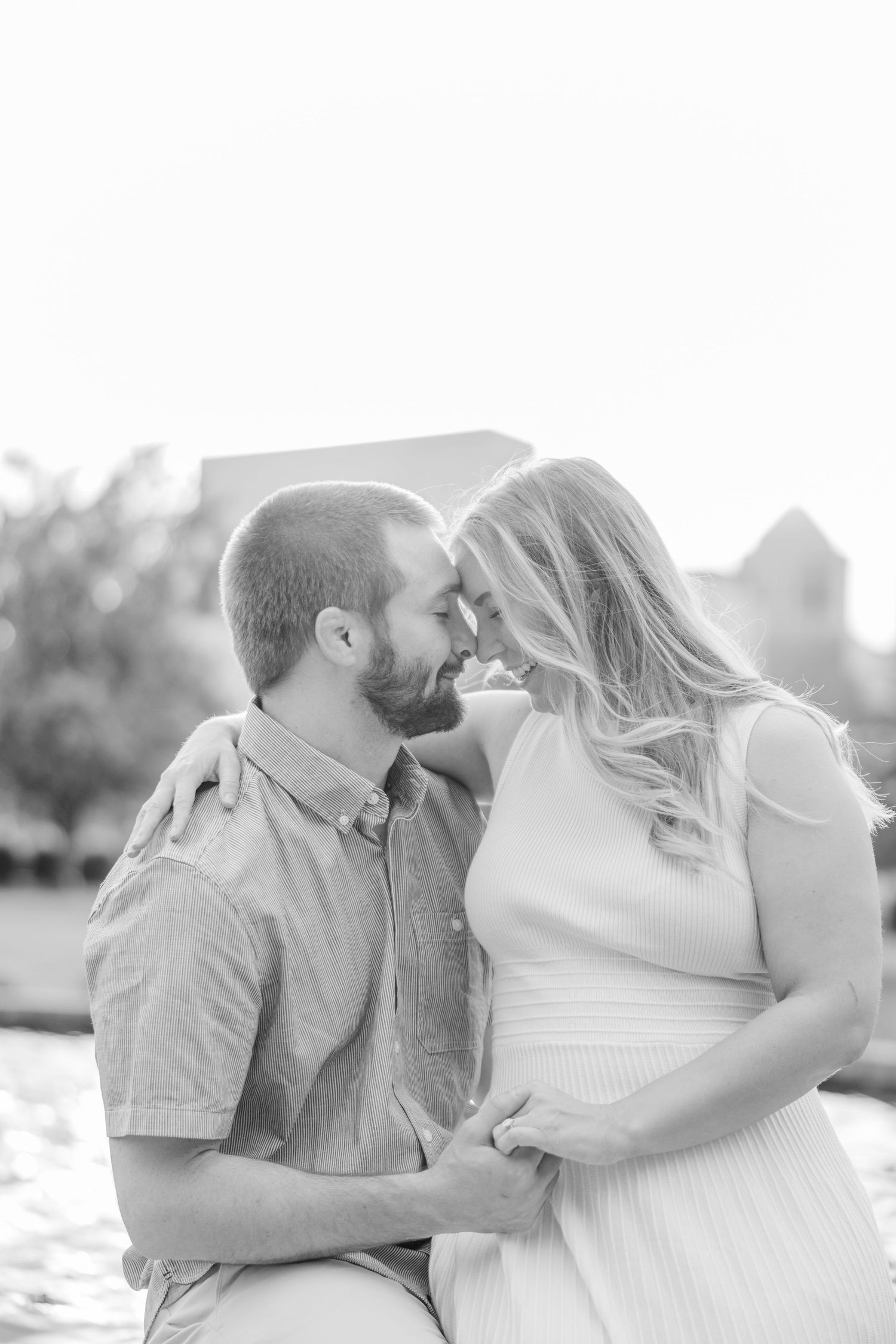 Intimate black and white portraits of a couple sharing romantic kisses outdoors.