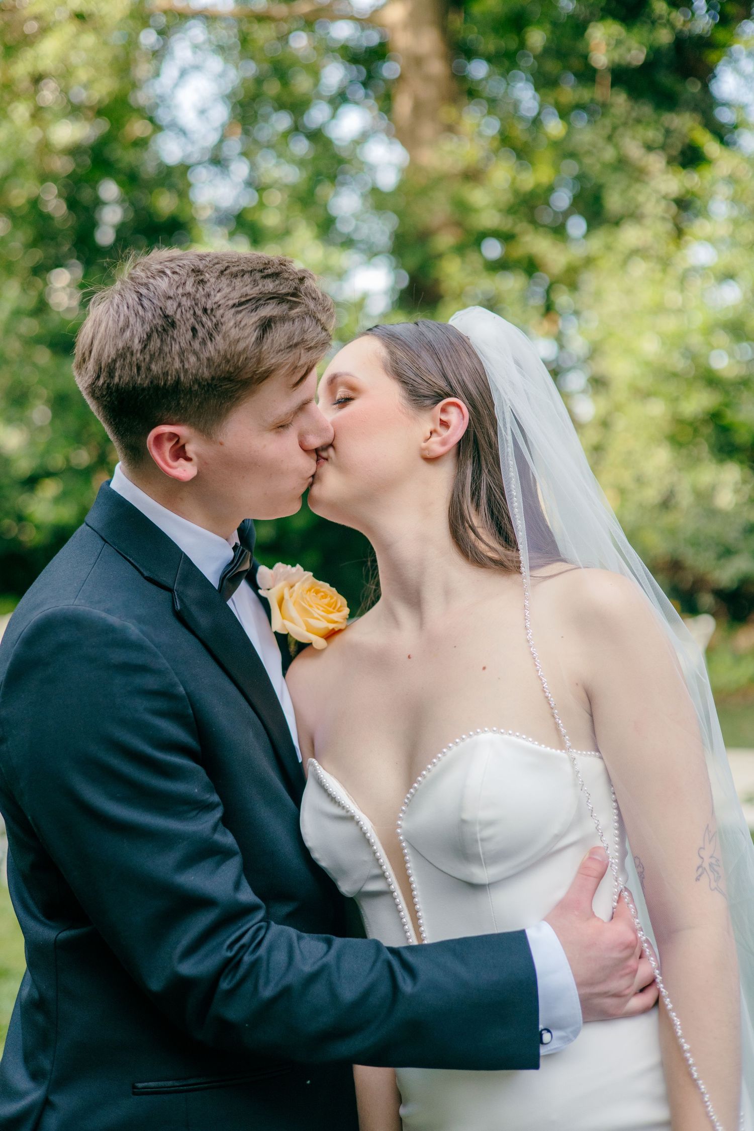 A romantic wedding moment captured in a garden setting with soft natural lighting.