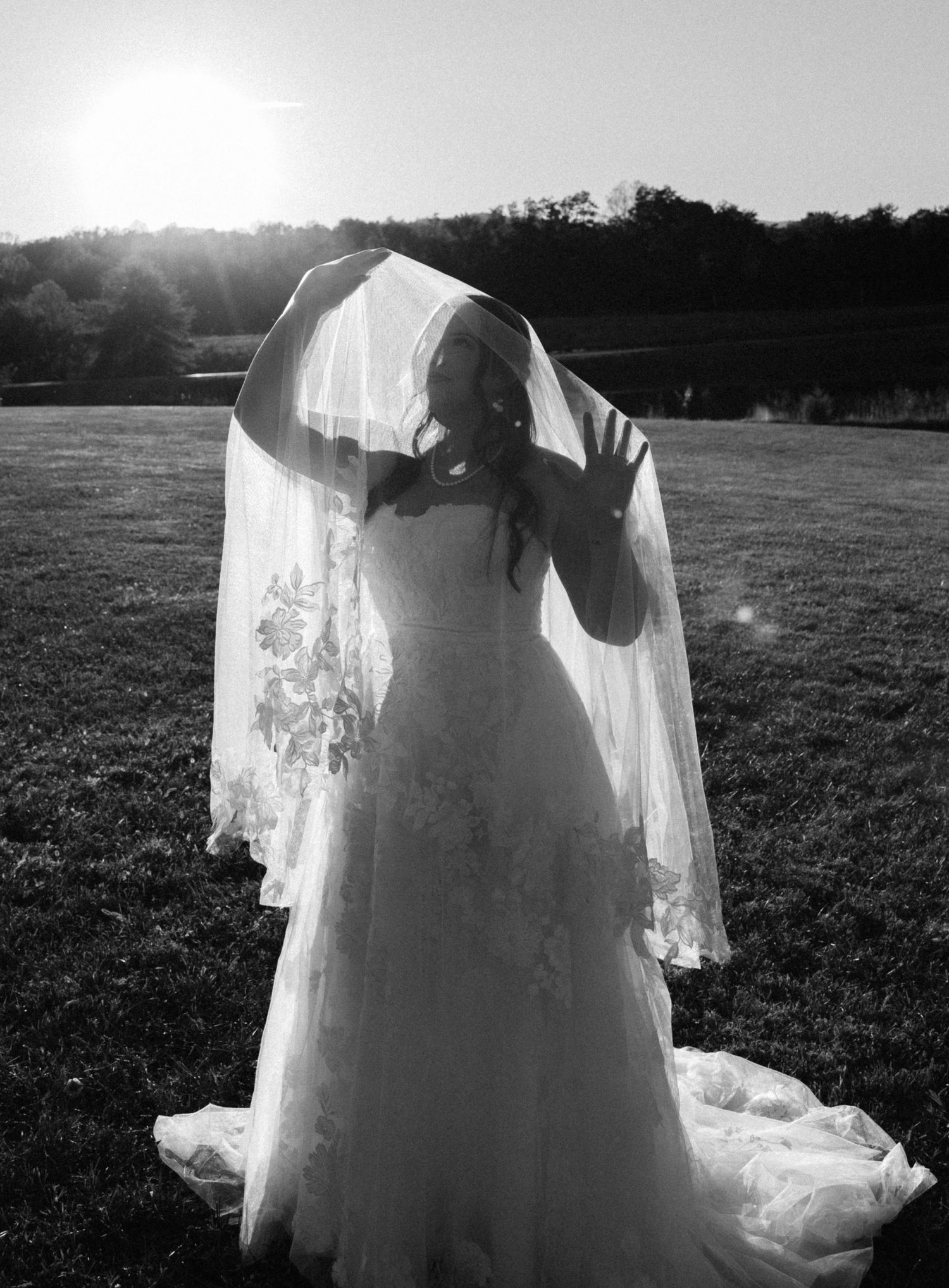 Black and white artistic shots of a flowing wedding dress and veil in a field.