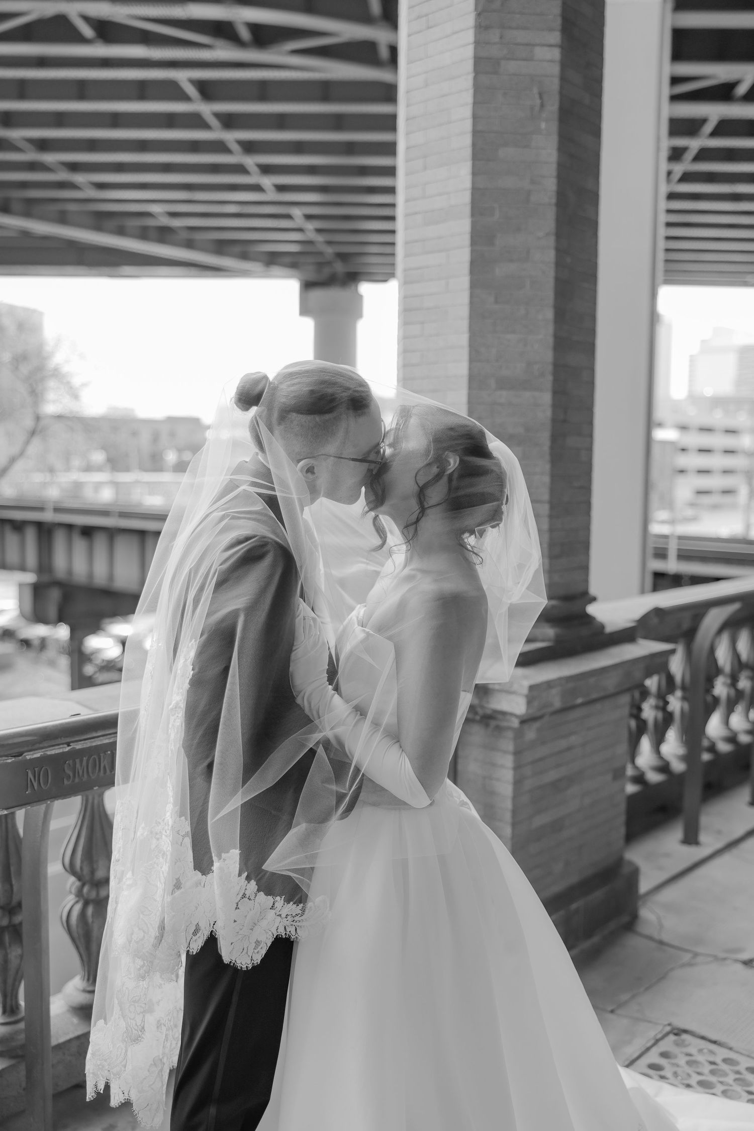 A black and white photo series showing a bride and groom in an intimate moment at a train station platform.