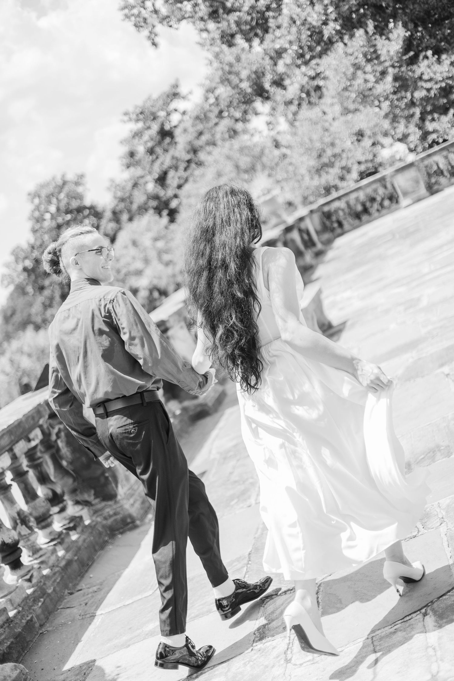 Black and white photo sequence showing playful dance movements in an outdoor setting.