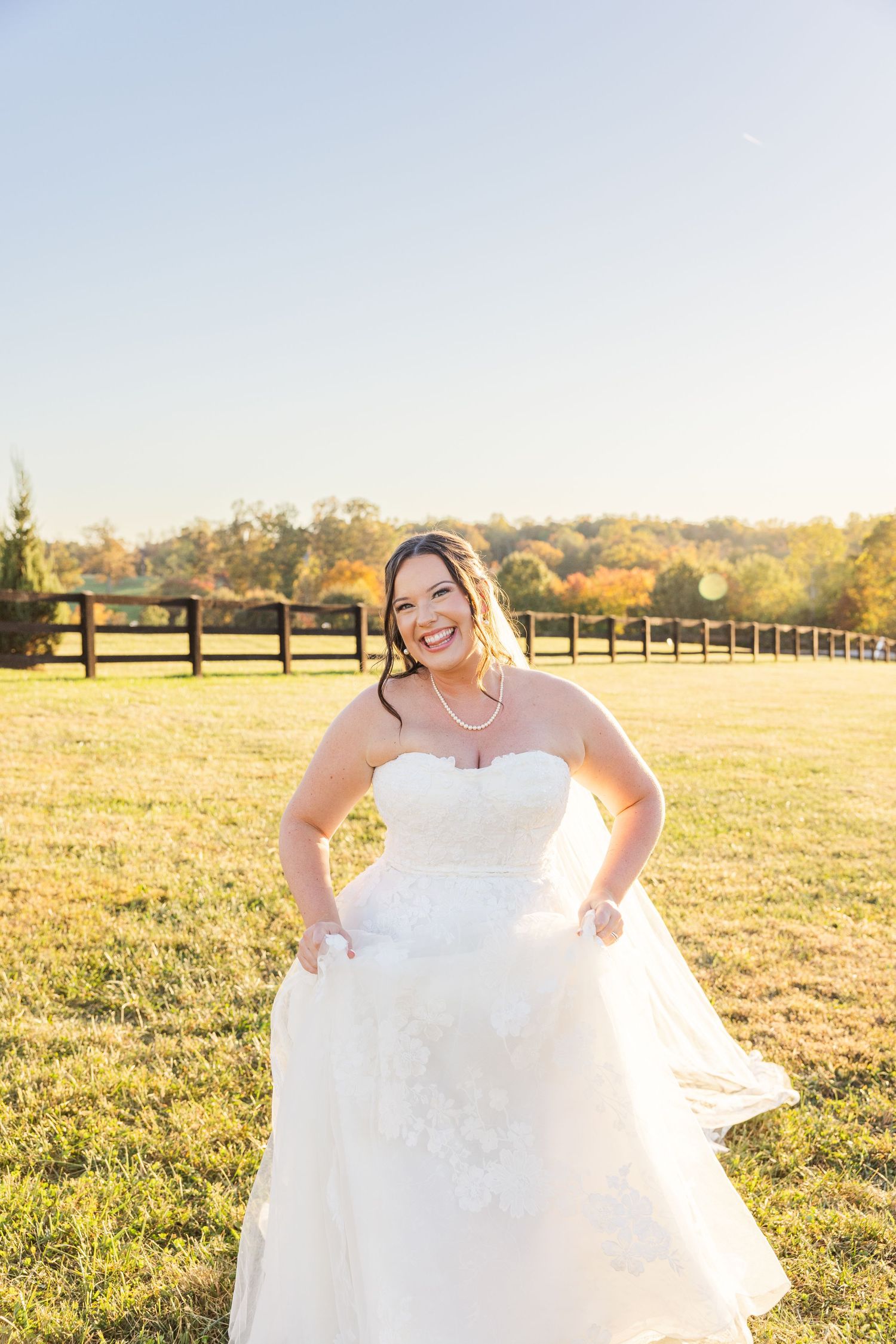 Joyful bridal portraits in a flowing white wedding dress during golden hour.