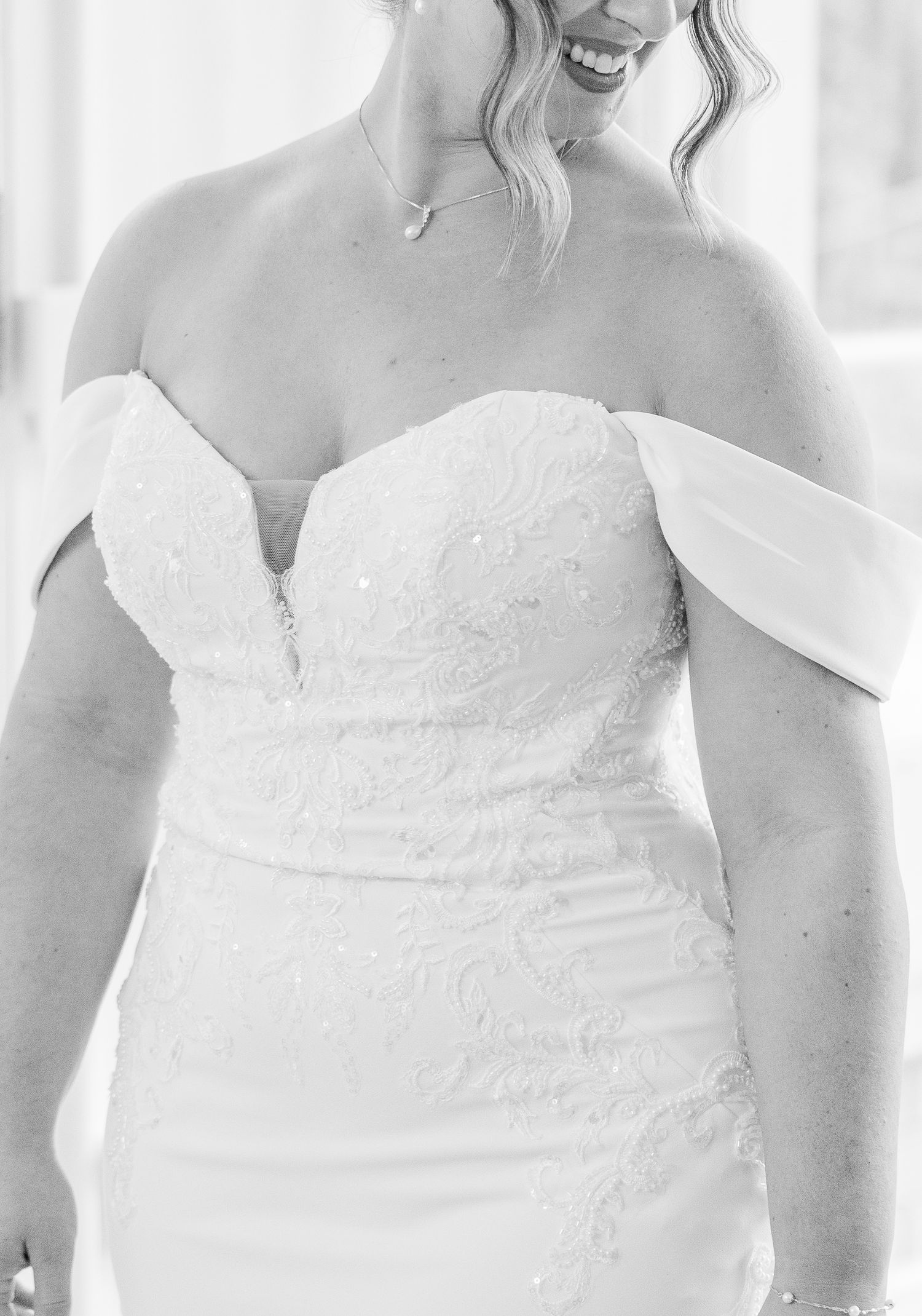A series of white wedding dresses with sweetheart necklines and lace details shown side by side in a bridal boutique.