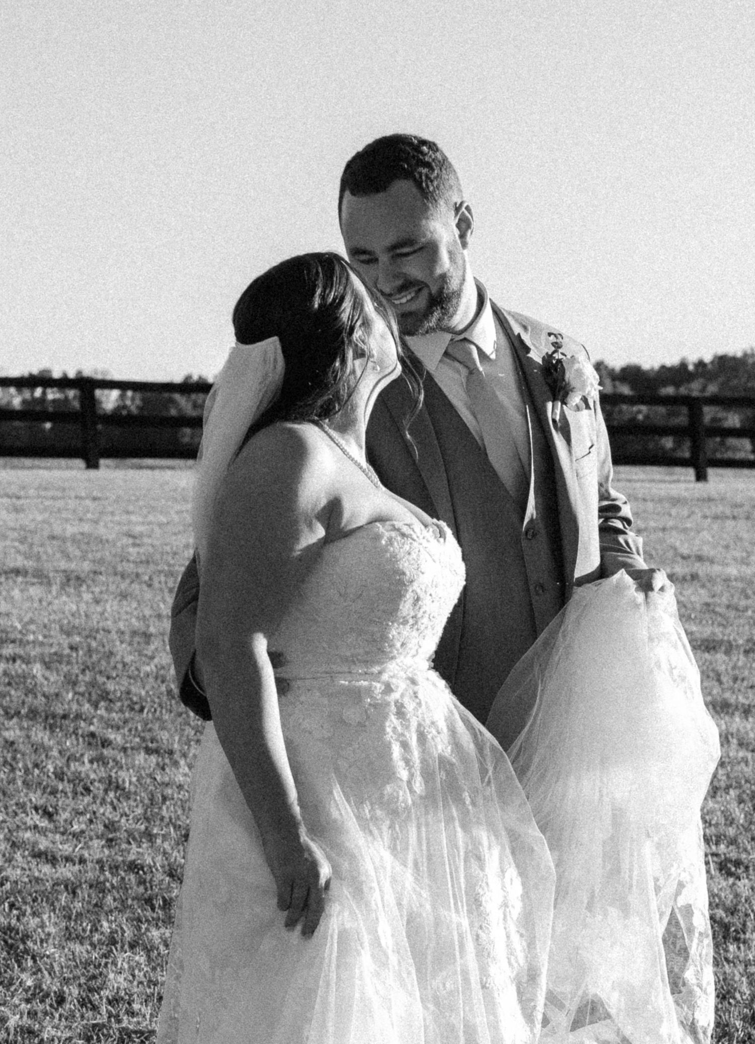 Black and white photo of a couple laughing together during their wedding photoshoot.