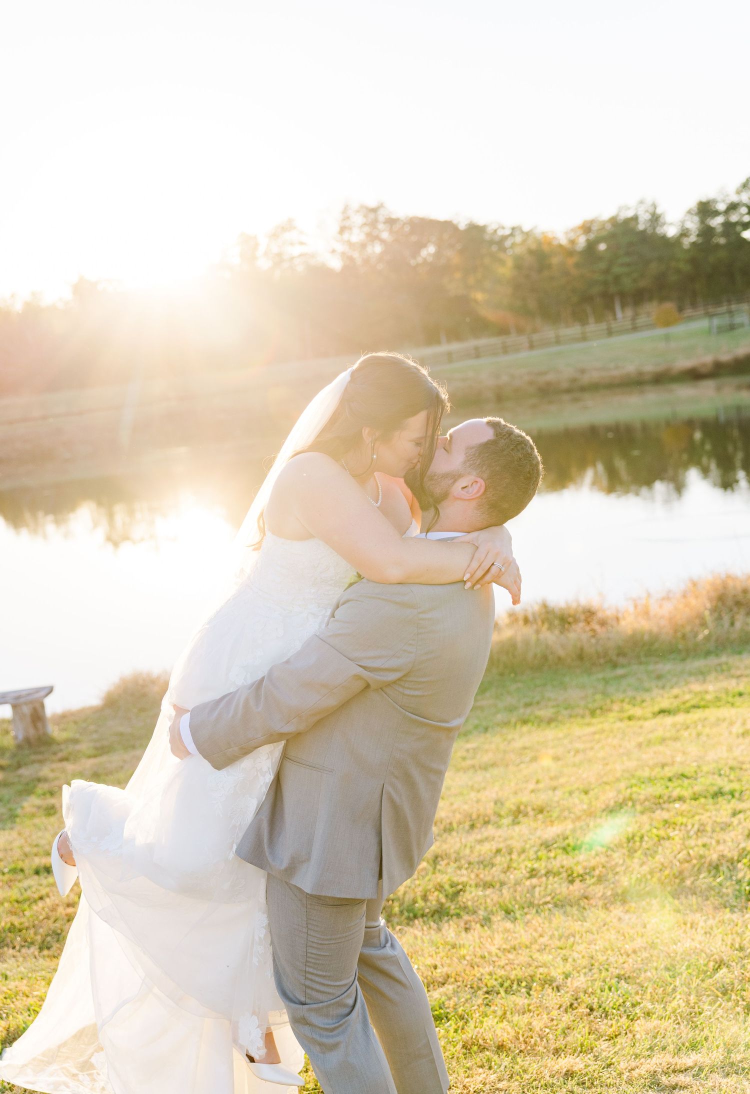 Romantic sunset wedding photos by a lake with golden hour lighting.