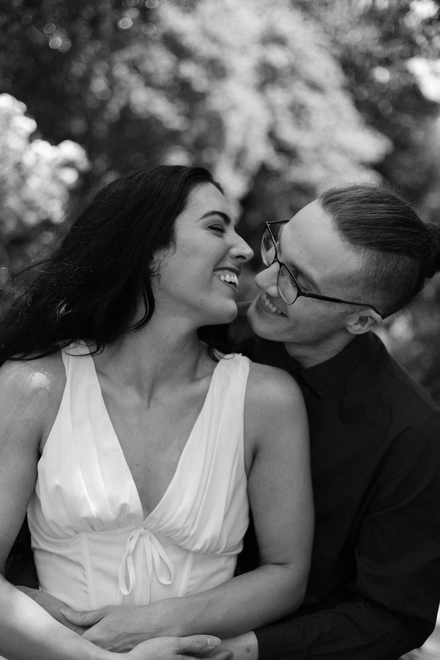 A romantic black and white photo sequence showing a couple sharing tender kisses in an outdoor setting.