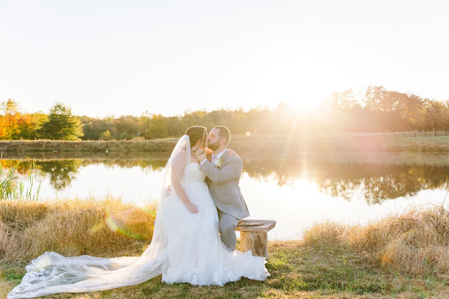 Romantic sunset wedding photos by a lake with golden light.