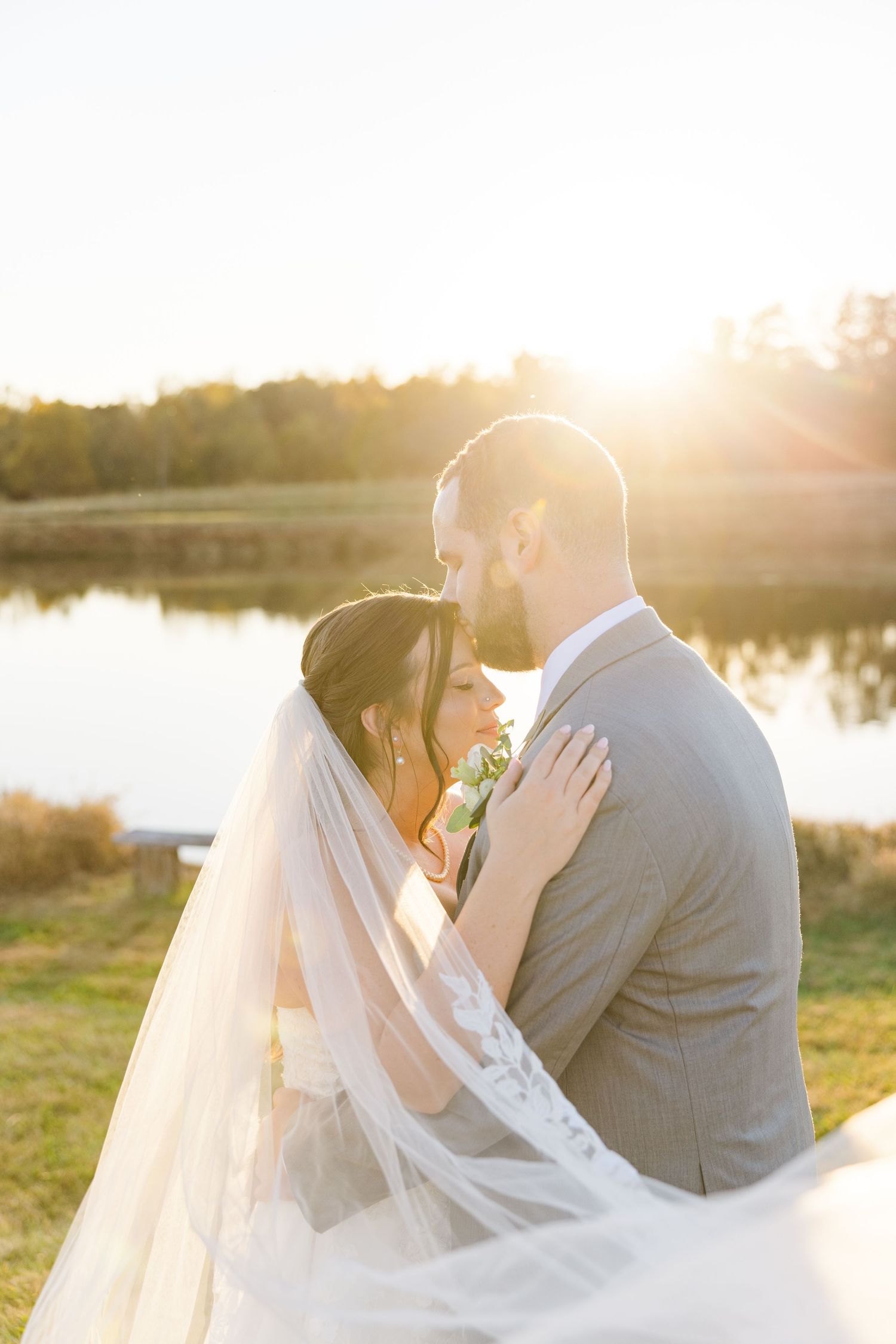 Golden sunset wedding portraits captured by a serene waterfront.