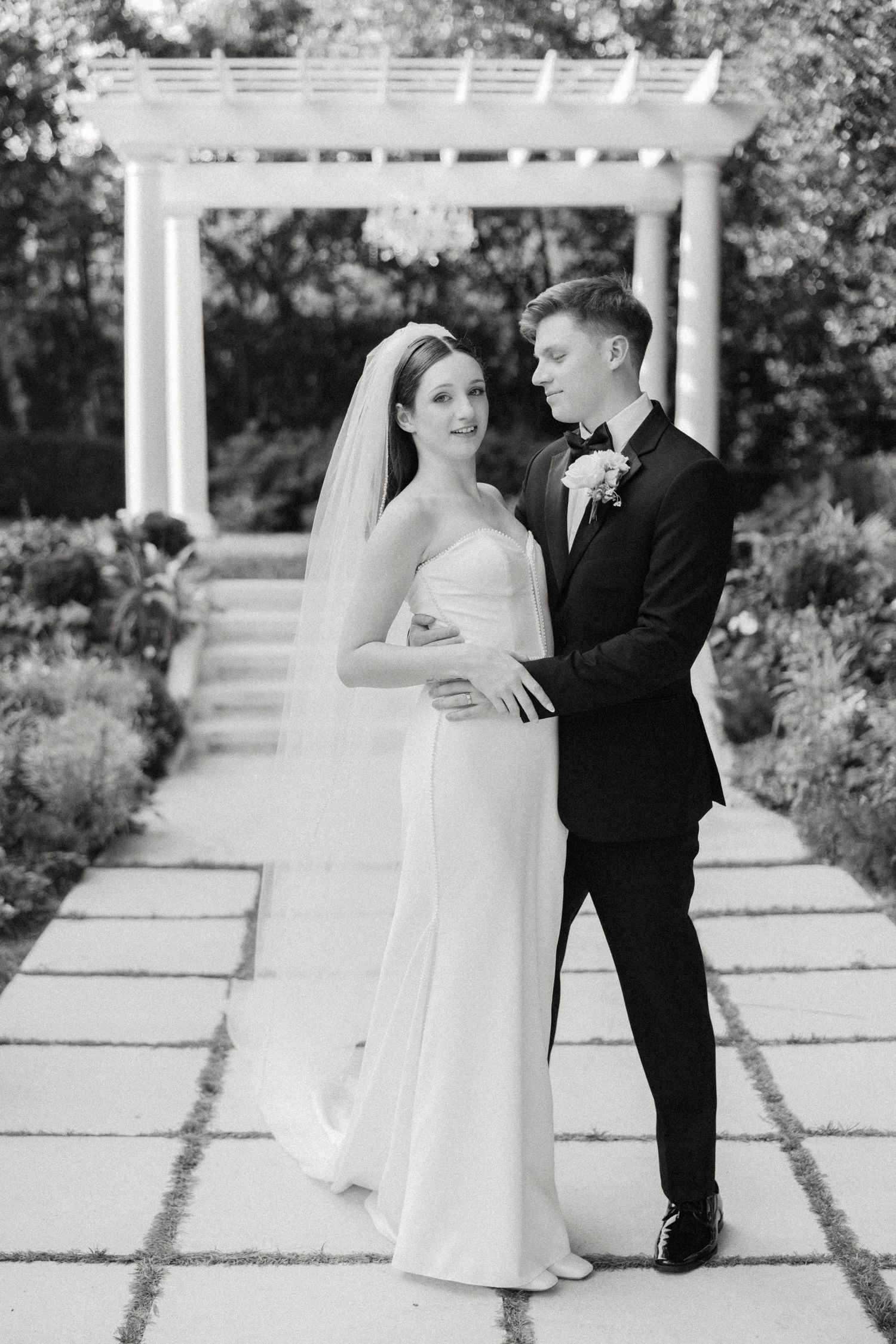 A romantic black and white wedding photo sequence captured under an elegant garden pergola.