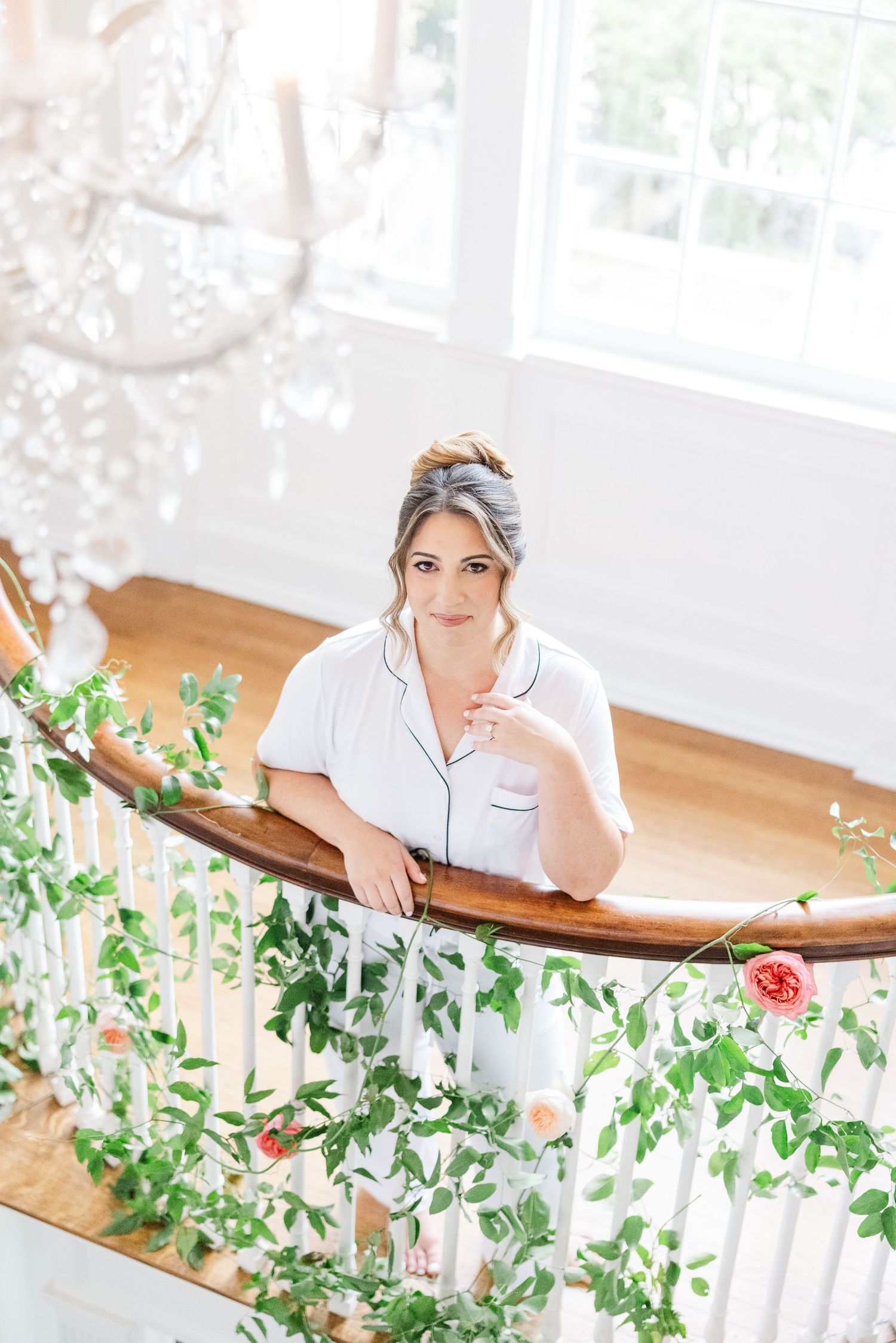 Elegant bridal preparation scene with greenery garland decorations in bright white room.