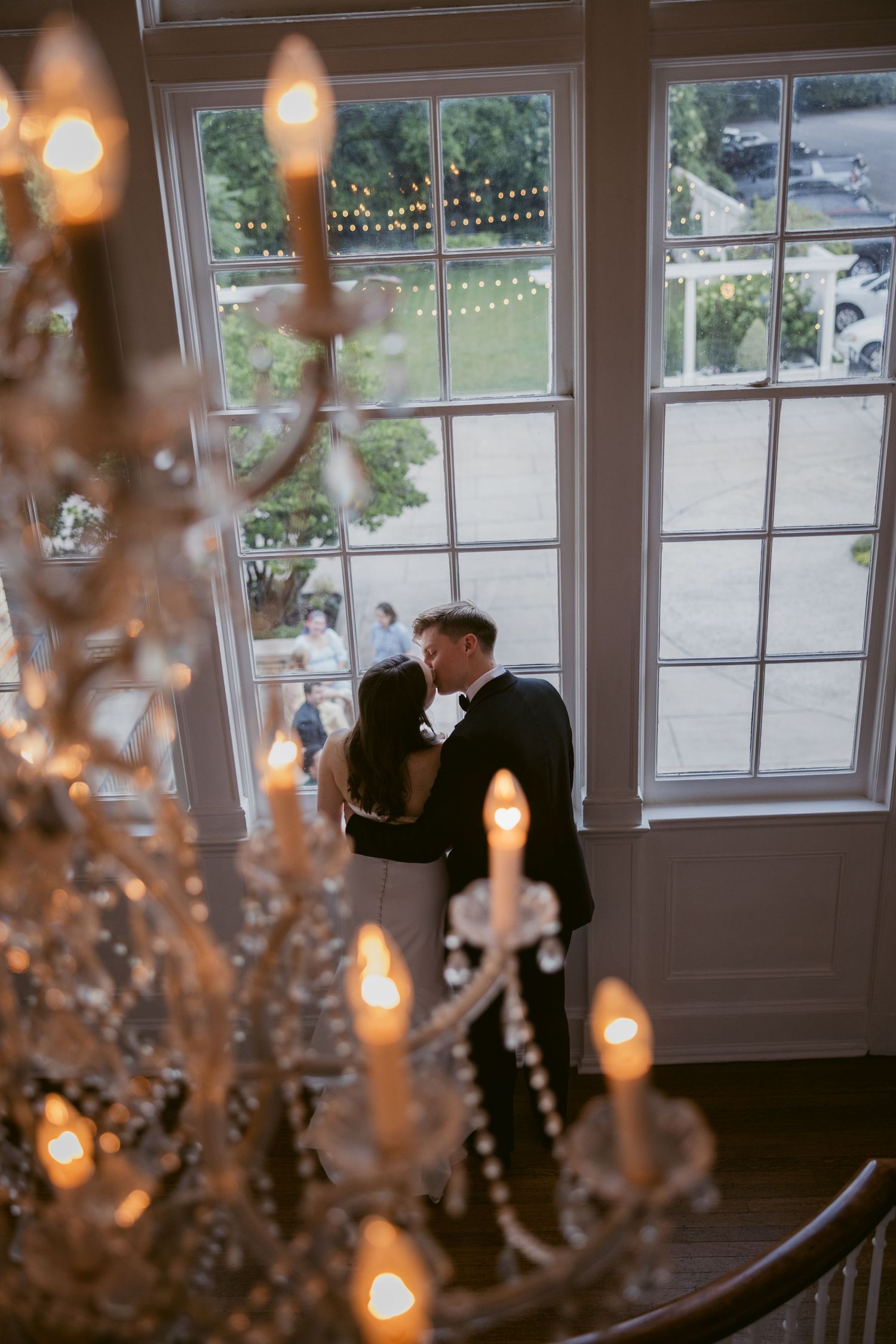 Crystal chandelier creates a romantic ambiance during an intimate wedding moment.