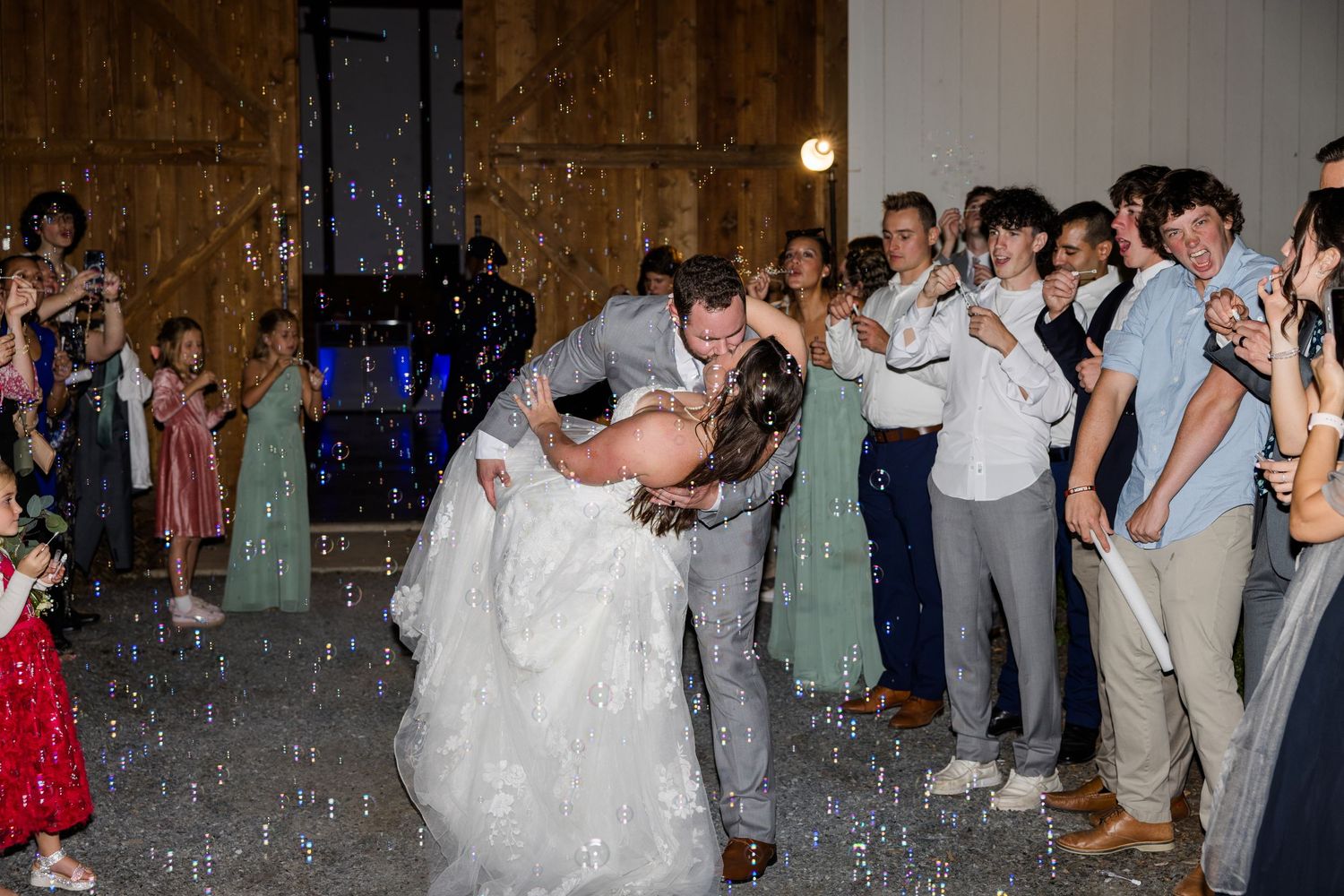 Wedding guests celebrate on dance floor with confetti and party lights.