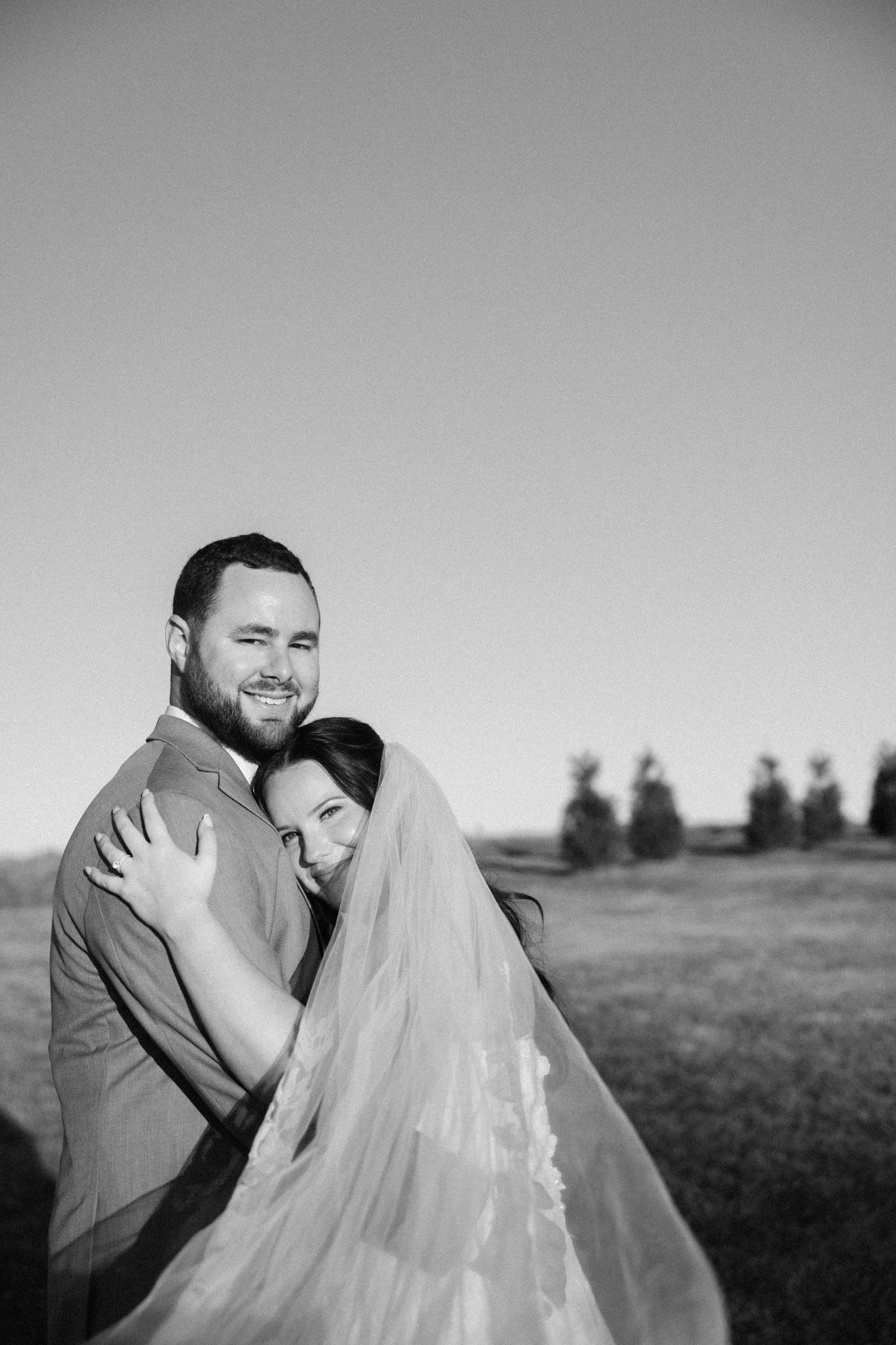 Black and white intimate wedding portraits captured in natural outdoor setting.
