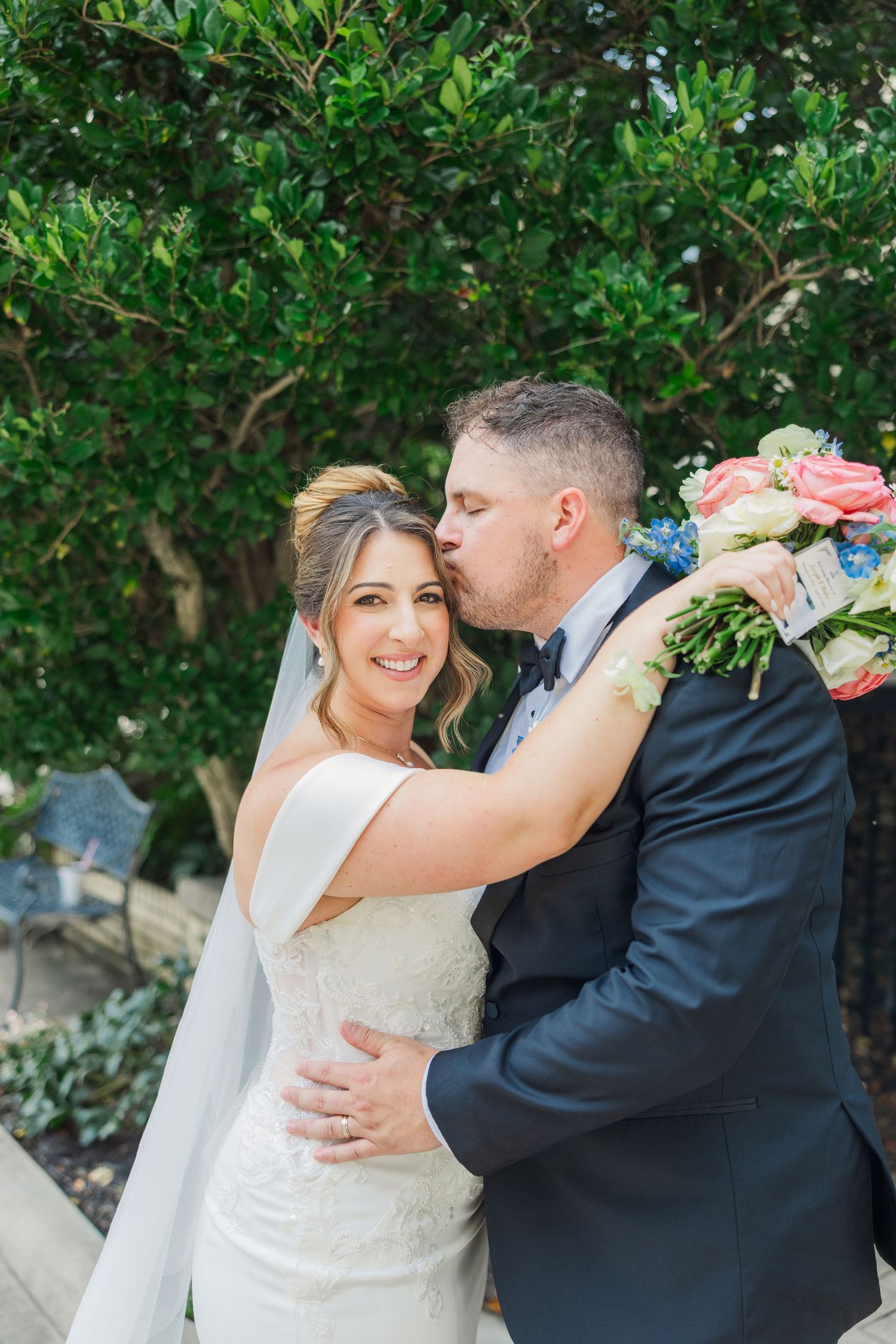 A romantic wedding photo series showing a couple embracing against a lush green garden backdrop.