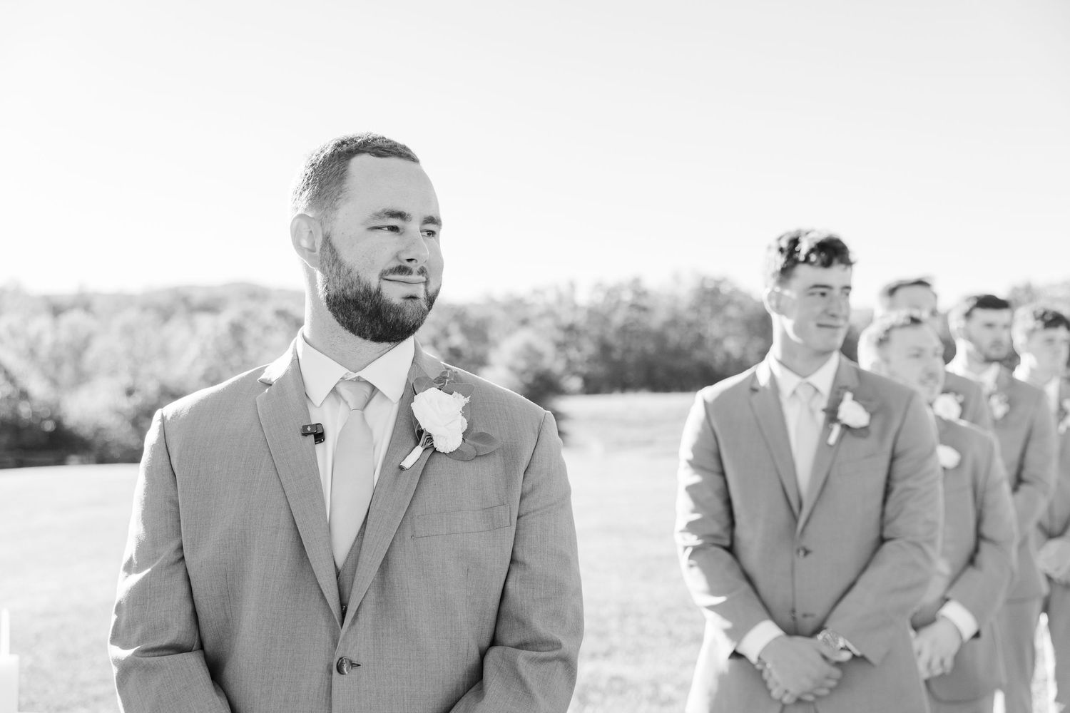 Black and white wedding party photos arranged in a horizontal row showing groomsmen in formal attire.
