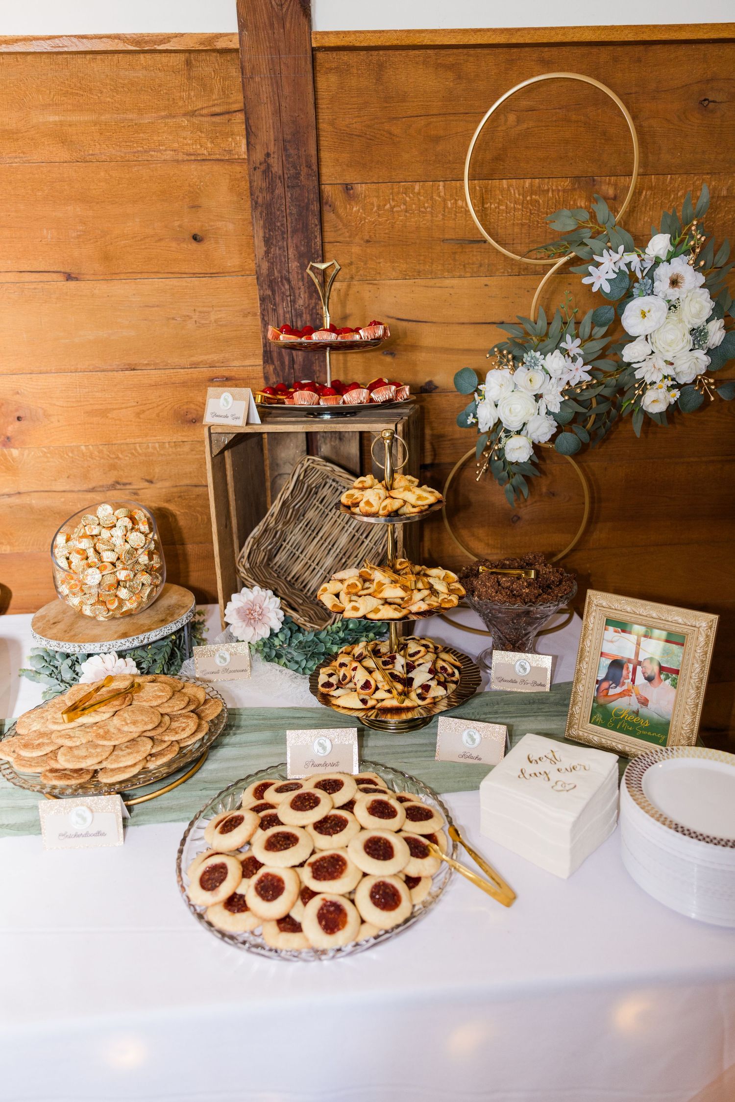 Dessert table display featuring various pies and treats decorated with floral accents on a white tablecloth.