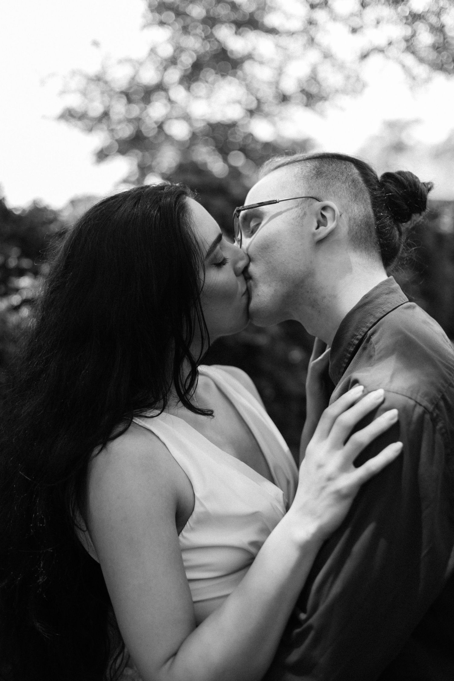 A series of intimate black and white photographs capturing a couple's passionate embrace outdoors.
