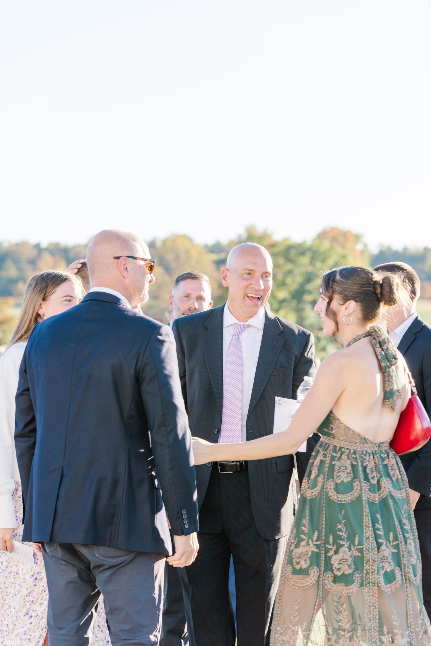 Wedding guests mingling and socializing during outdoor reception event.