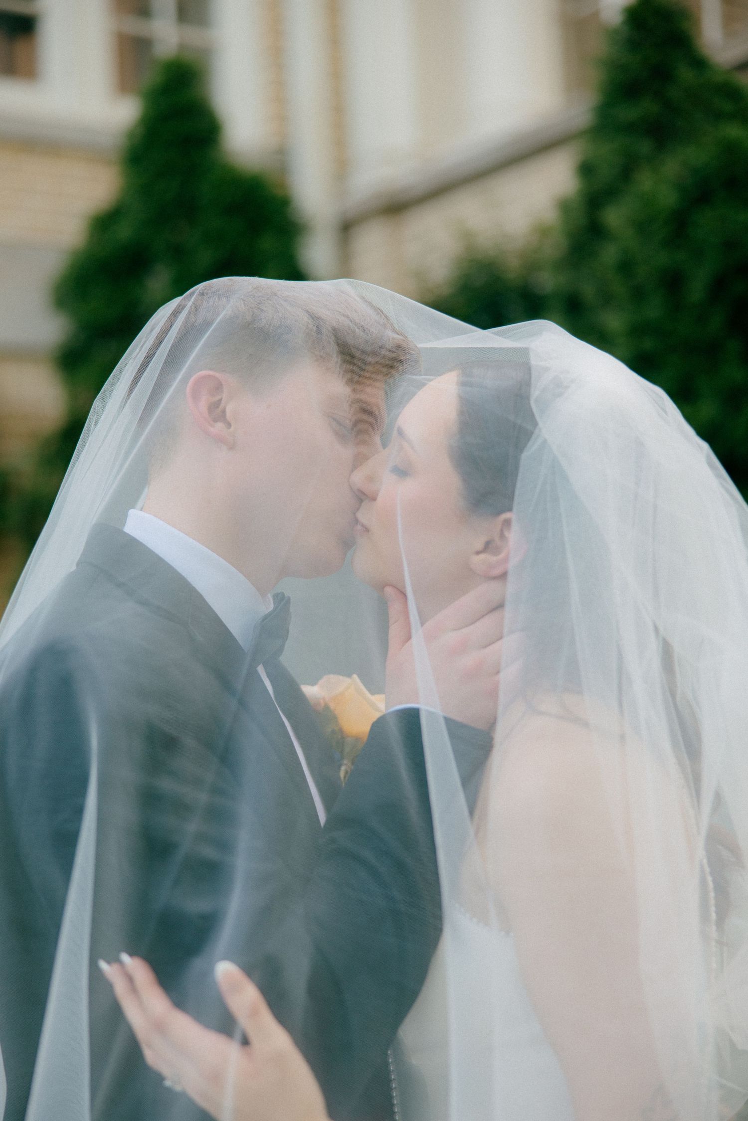 A sequence of romantic wedding kiss photos with a flowing white veil.