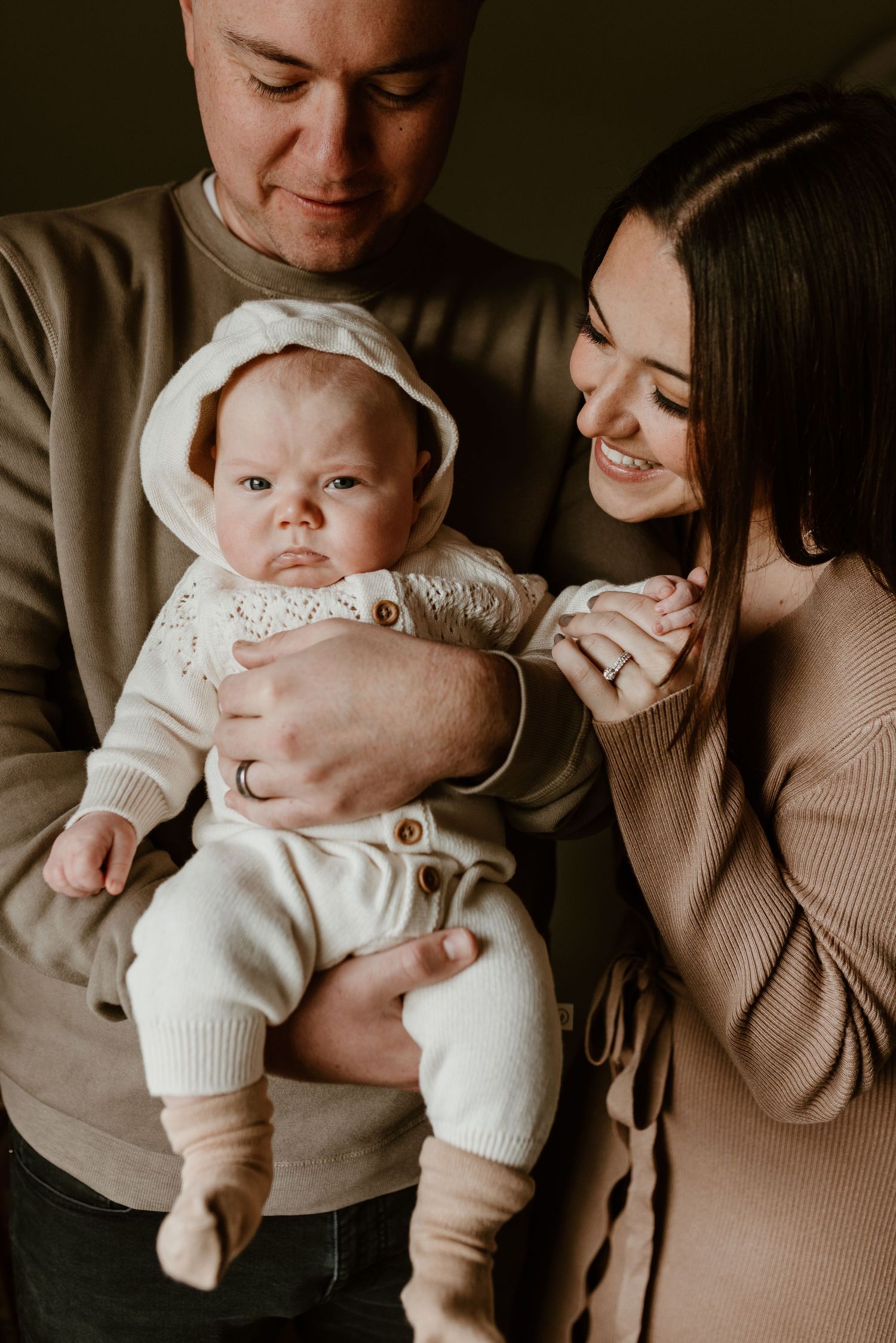 A loving family moment with a baby in a cozy white outfit.