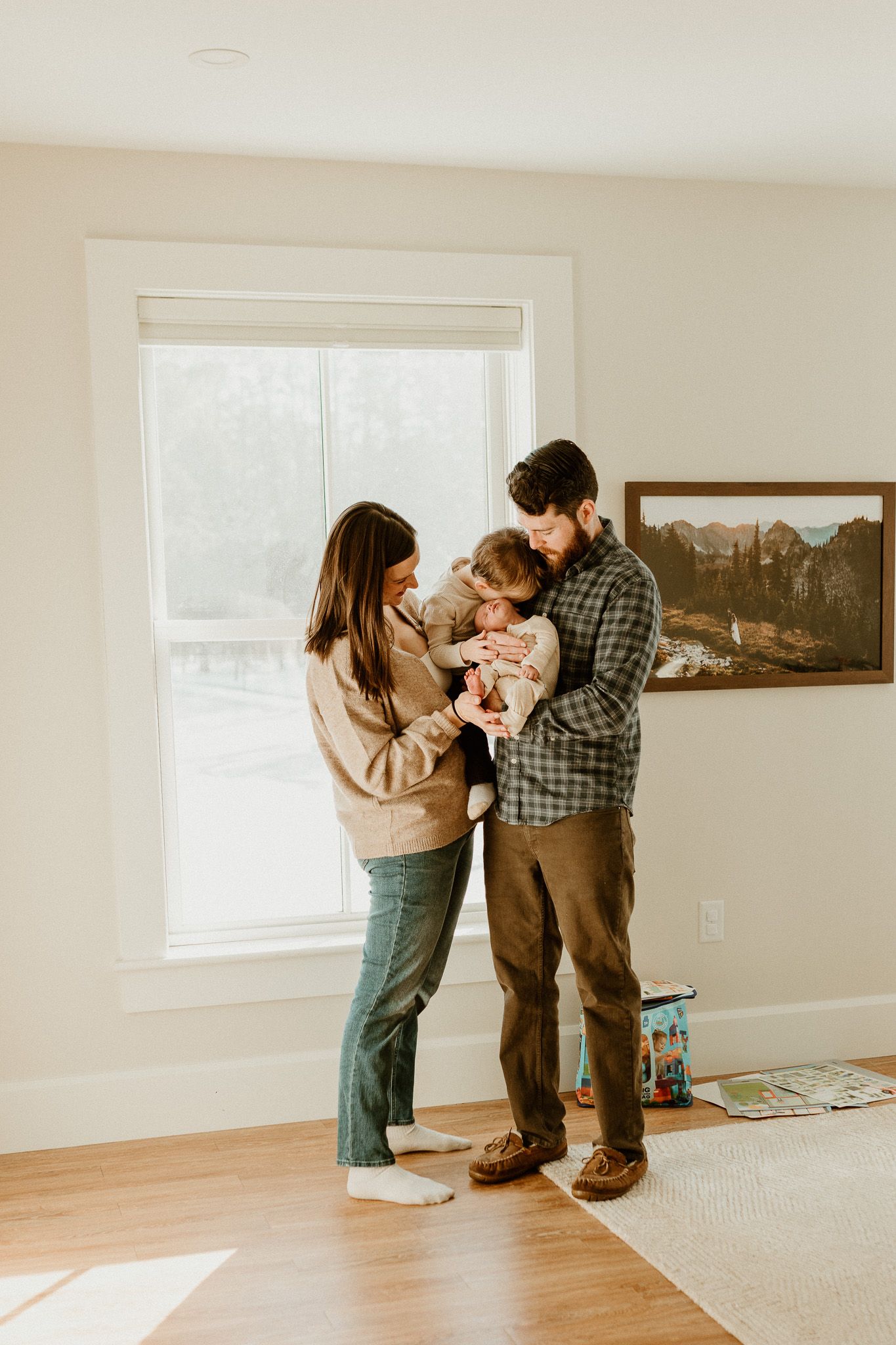 Family sharing tender moments in sunlit room with hardwood floors.