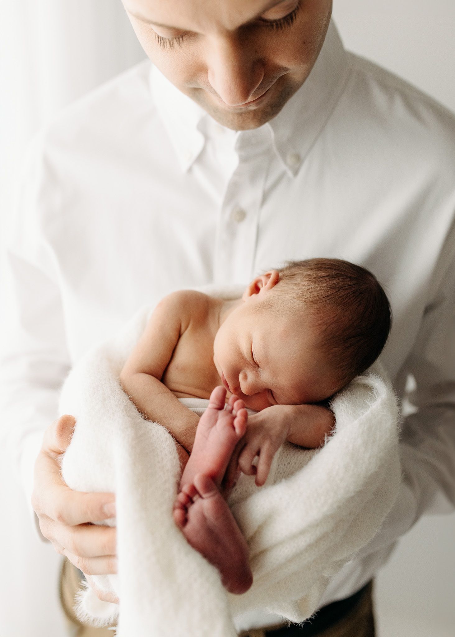 Series of tender moments with newborn baby wrapped in white blanket.
