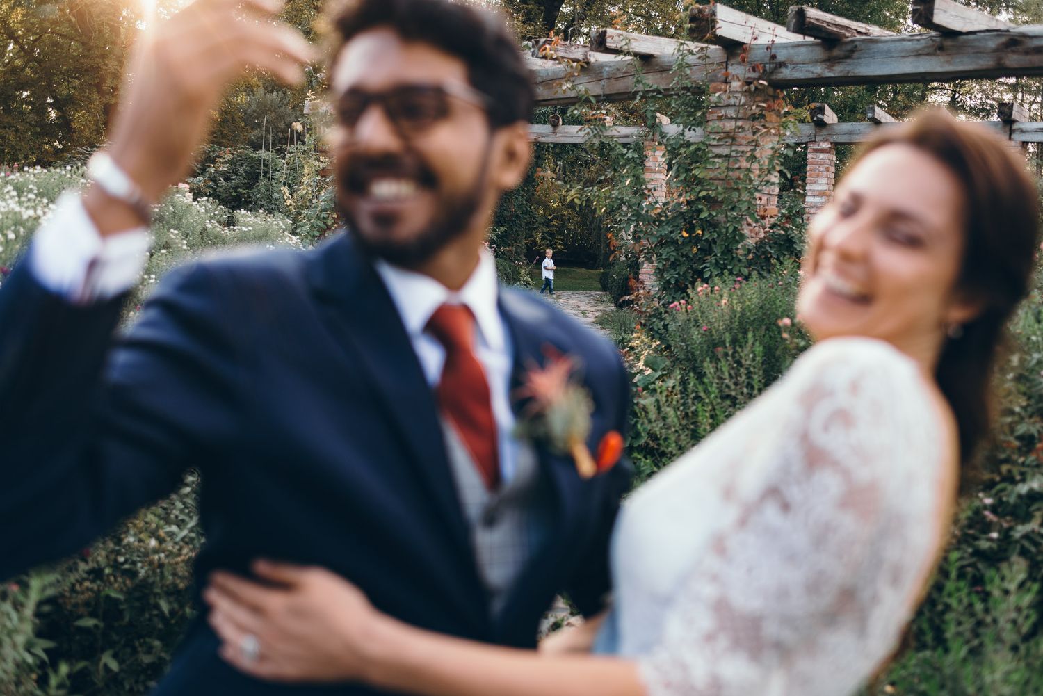Couple shares an intimate moment in a garden setting during their wedding celebration.