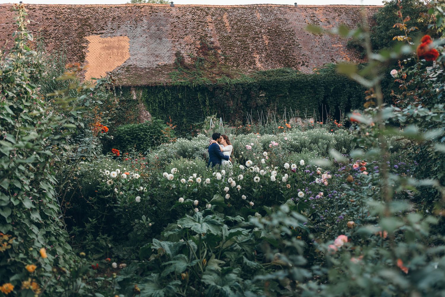 Garden wedding venue features rustic brick walls and lush greenery.
