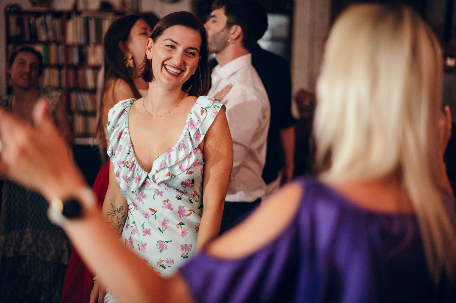 Wedding celebration in a library with guests dancing and enjoying the festivities.