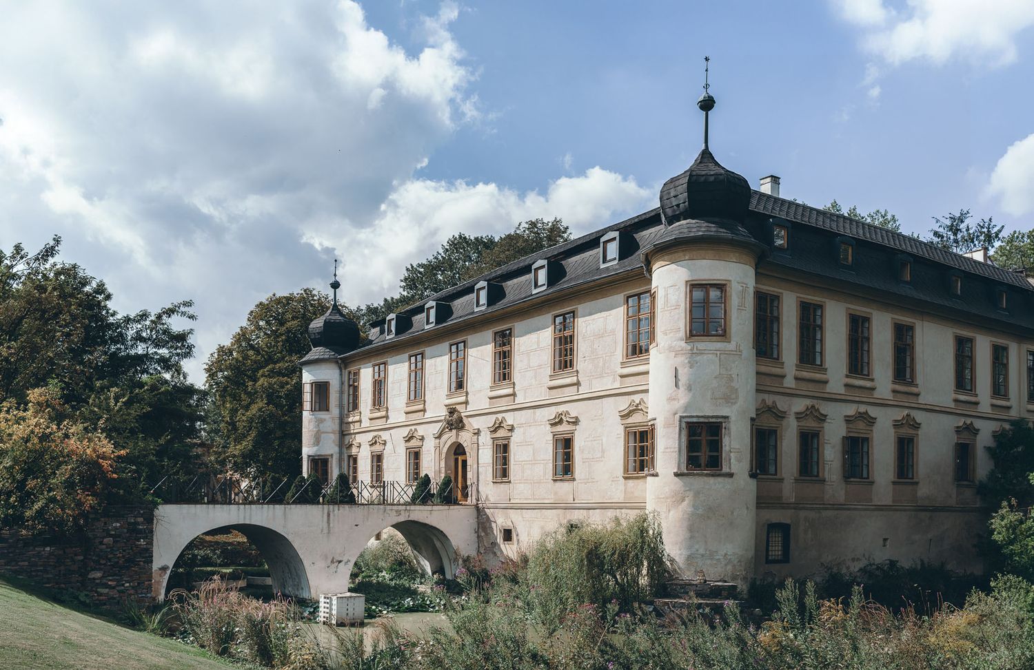 Panoramic view of a grand historic mansion estate with manicured grounds.