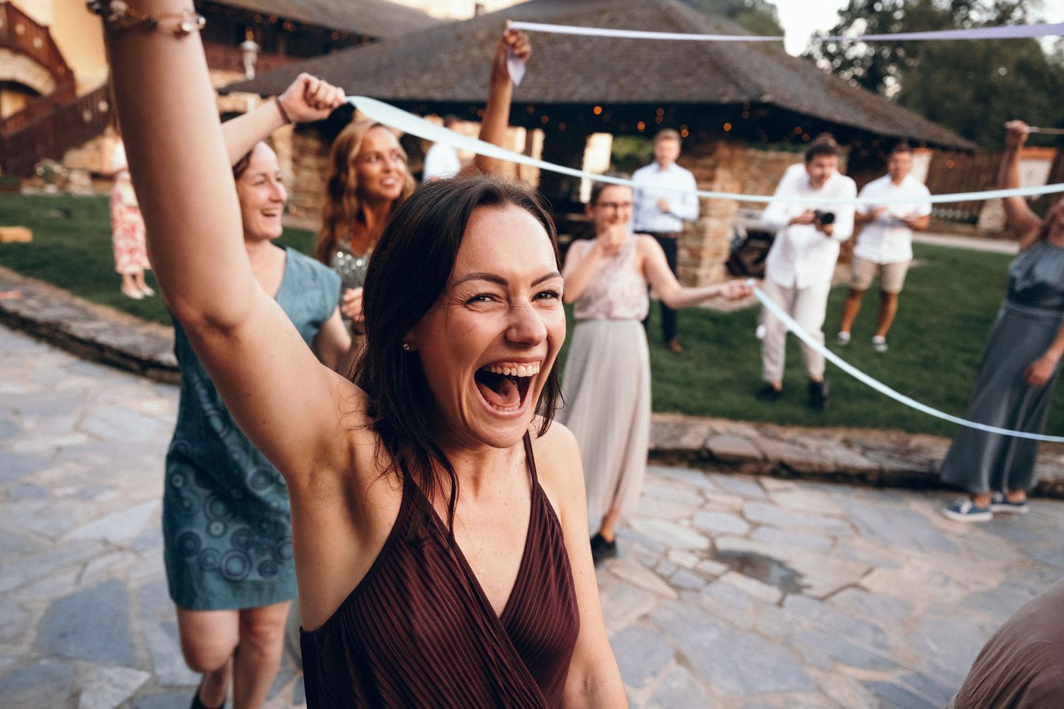 Joyful celebration with party guests dancing and having fun outdoors.