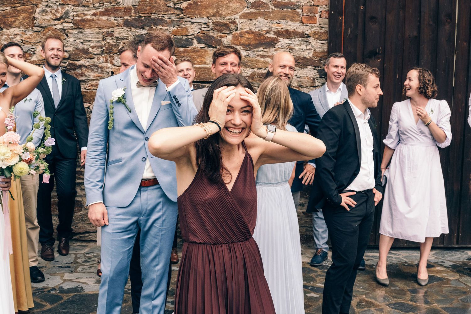 Wedding guests gathered outside a rustic brick venue during a celebration.