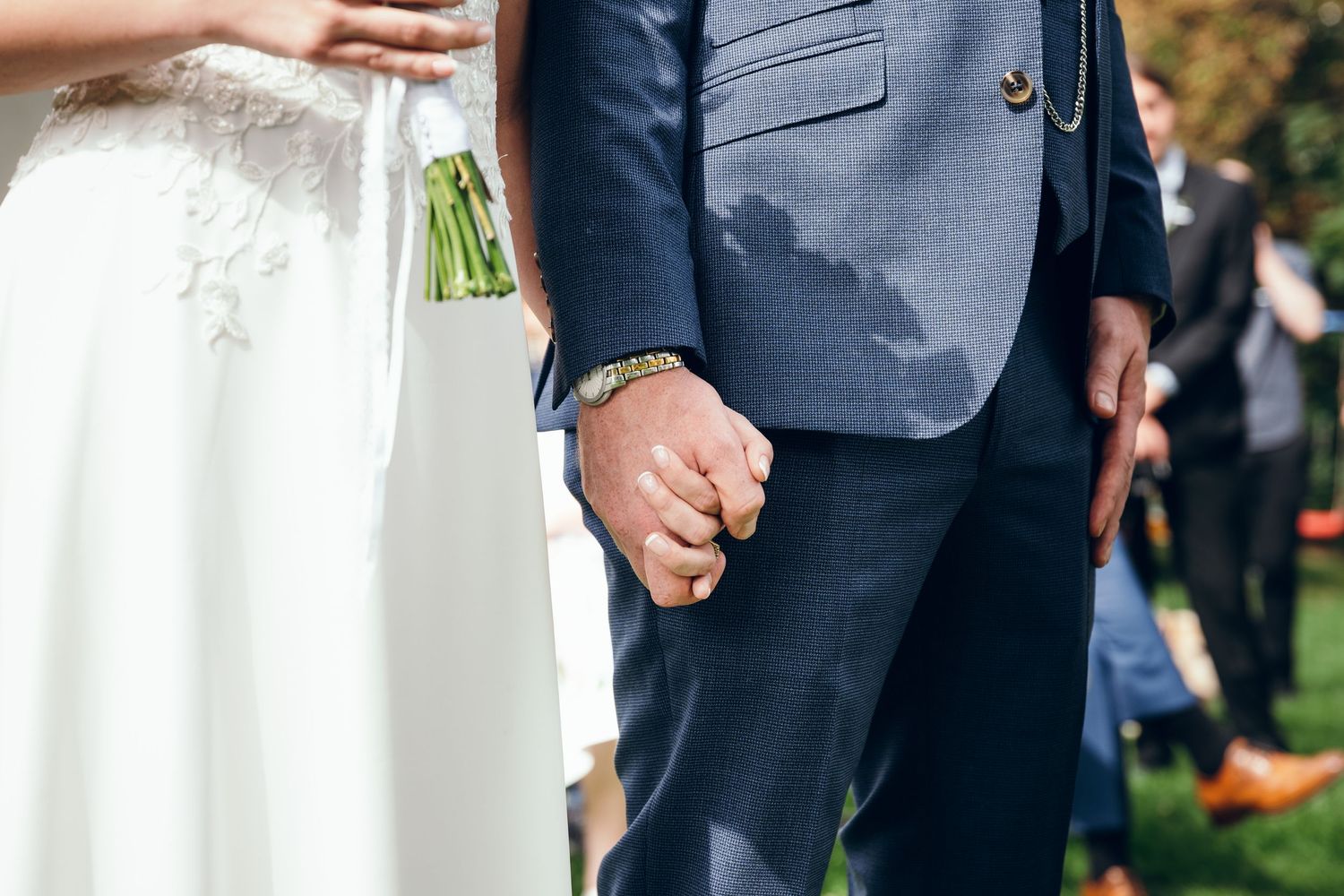 Wedding party members stand together during outdoor celebration.