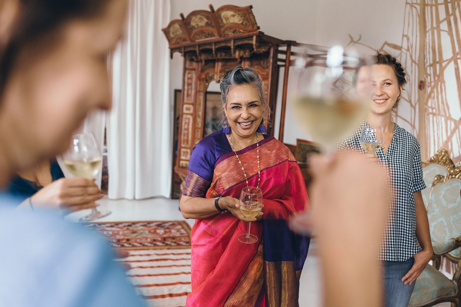 Wedding guests raise glasses in celebration during a festive reception.
