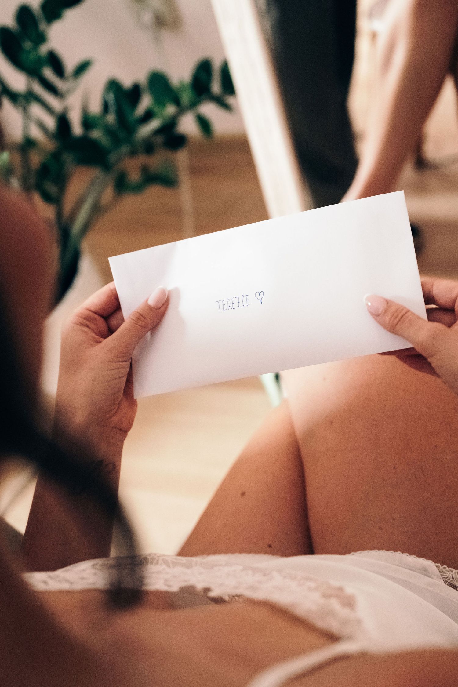 Close-up of hands holding a white envelope in soft natural light.