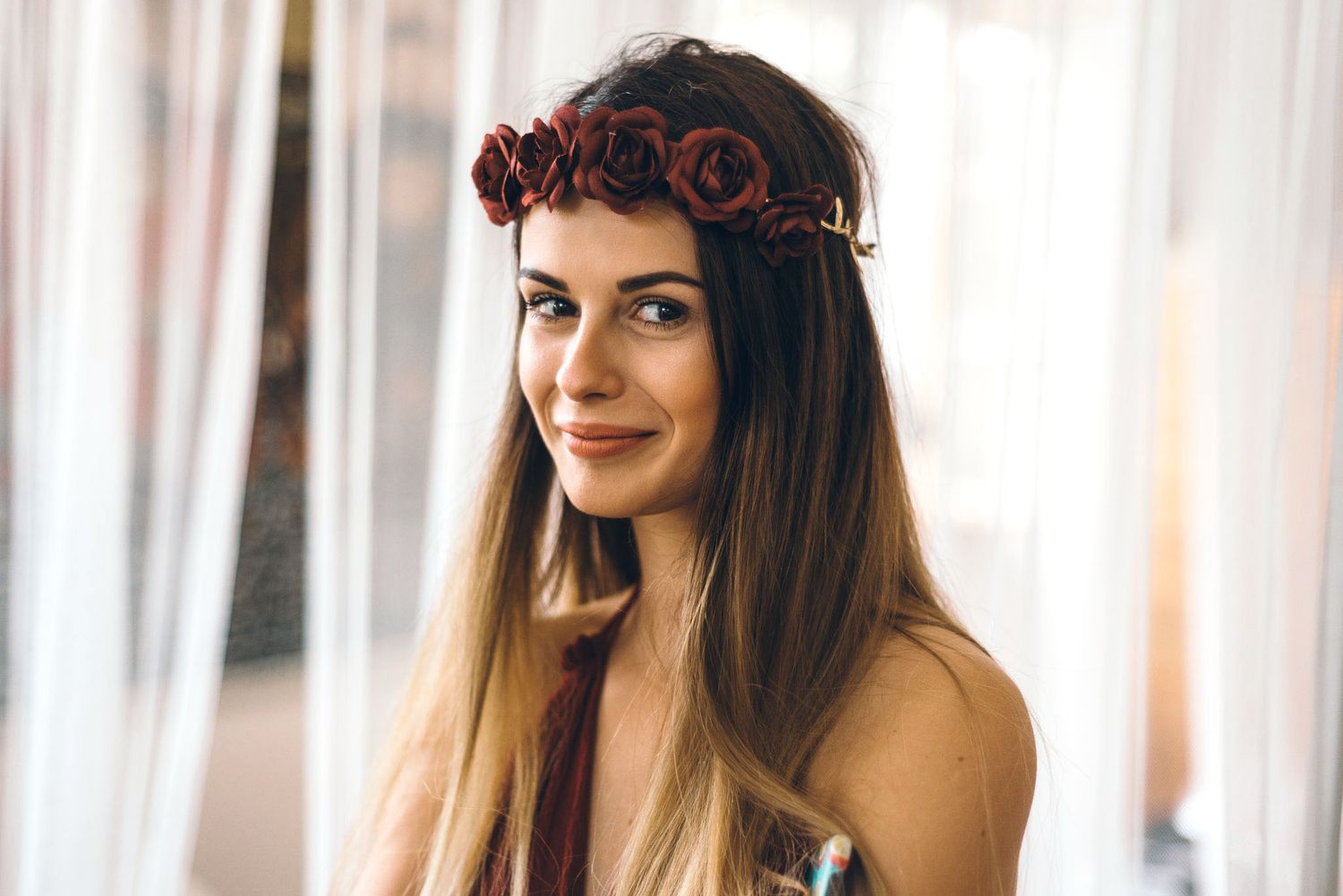 Romantic portrait with floral crown and soft window lighting.